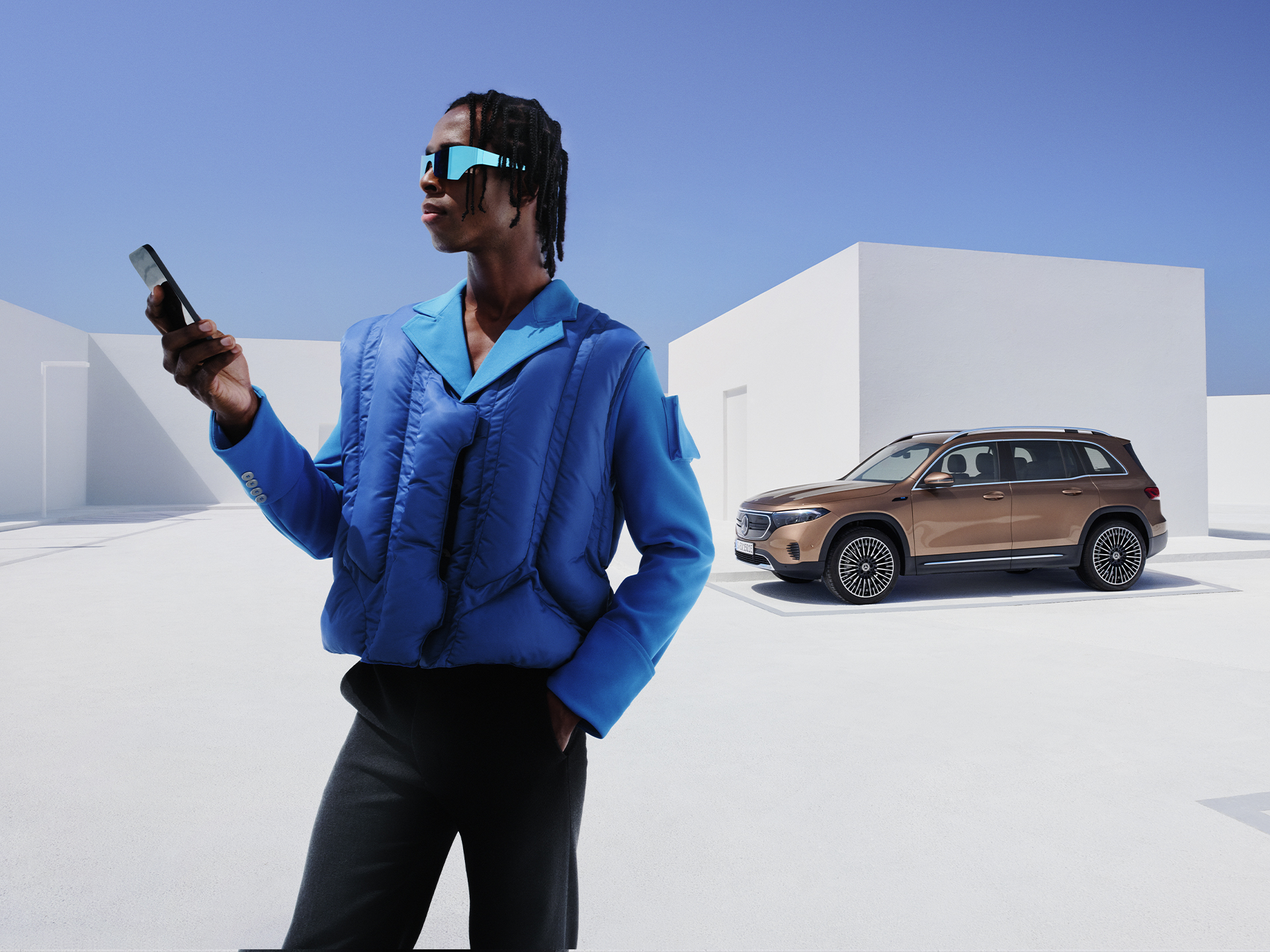 Mercedes-Benz App | Applicazioni | Mercedes-Benz Persona con smartphone davanti a un SUV Mercedes-Benz.