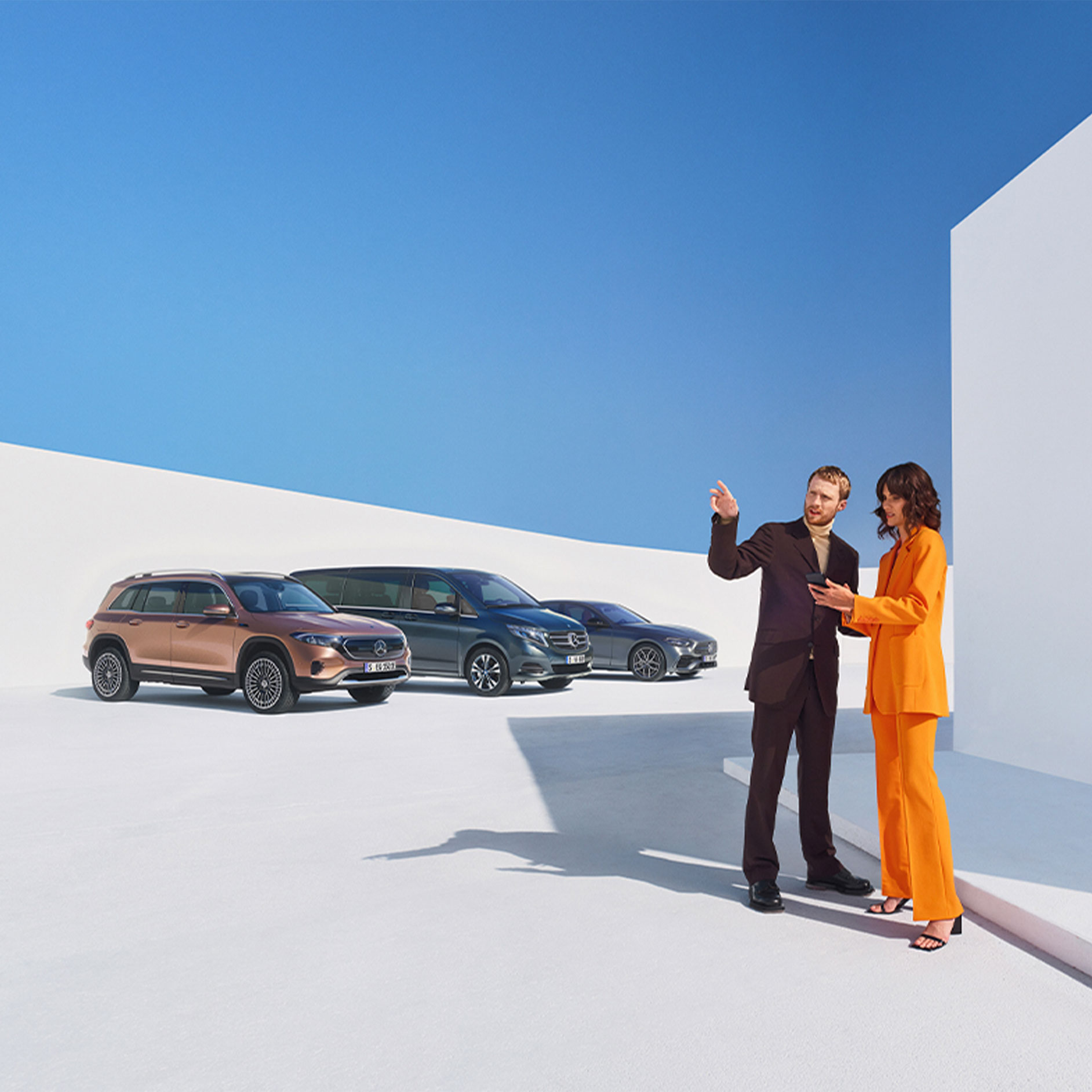 Services connectés pour les clients professionnels | Services connectés | Mercedes-Benz Un homme et une femme devant plusieurs véhicules Mercedes-Benz.