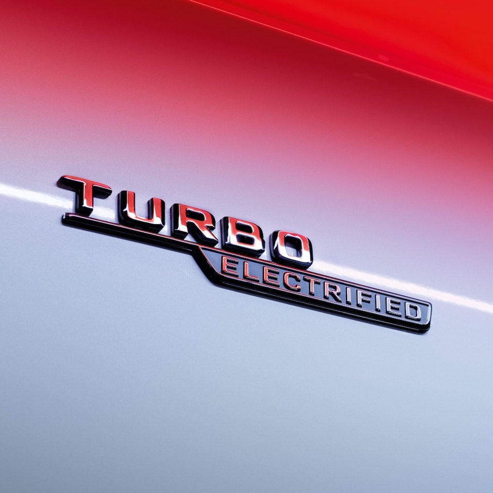Detailaufnahme des TURBO ELECTRIFIED-Emblems an den vorderen Kotflügeln.