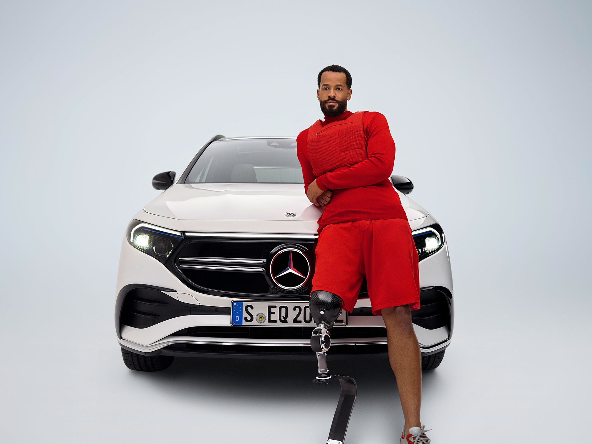 La Mercedes-Benz EQA transformée pour les personnes à mobilité réduite dans une vue avant et un homme avec prothèse de jambe.