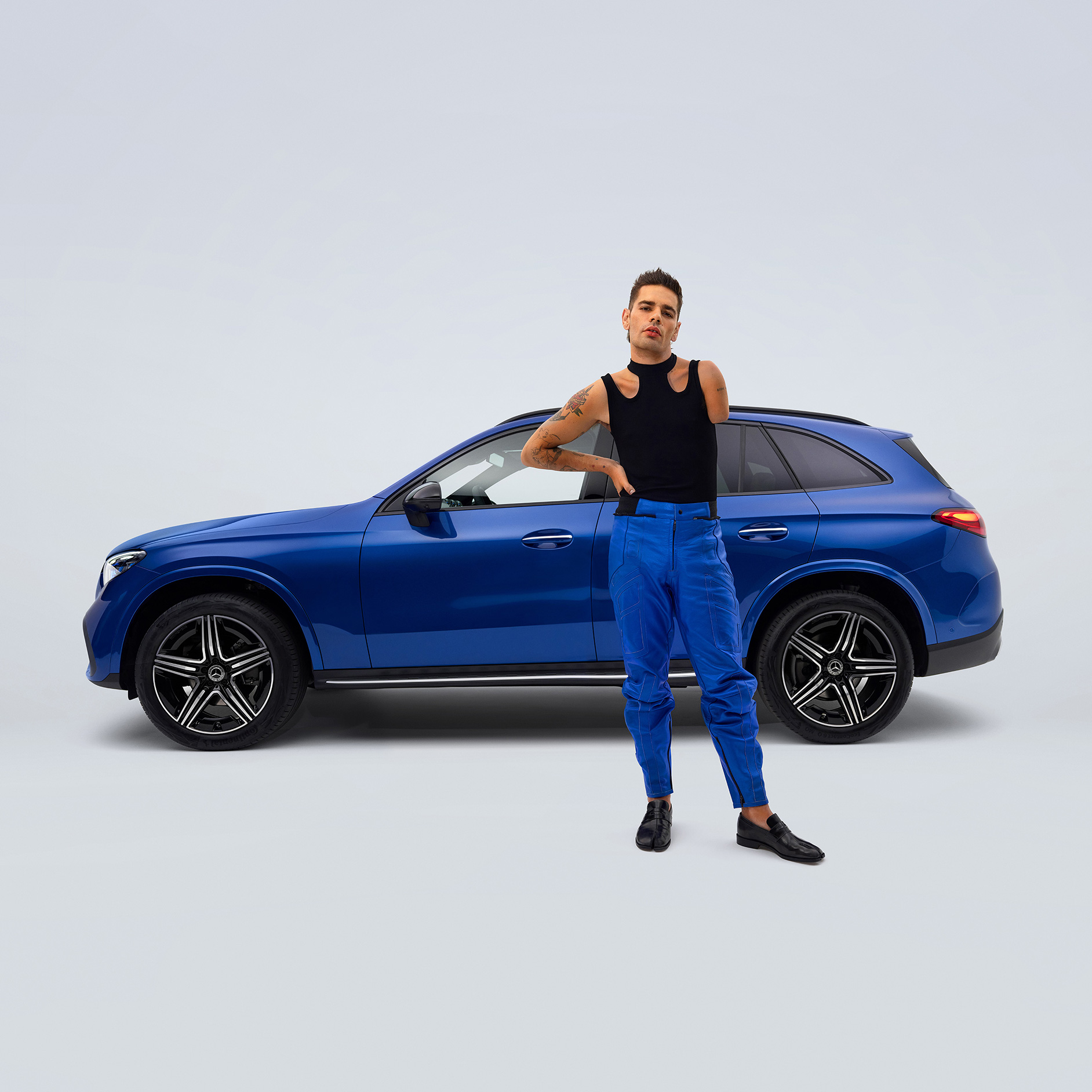 Ausili per lo sterzo e i comandi | Ausili alla guida | Mercedes-Benz Uomo davanti a un SUV Mercedes-Benz GLC.