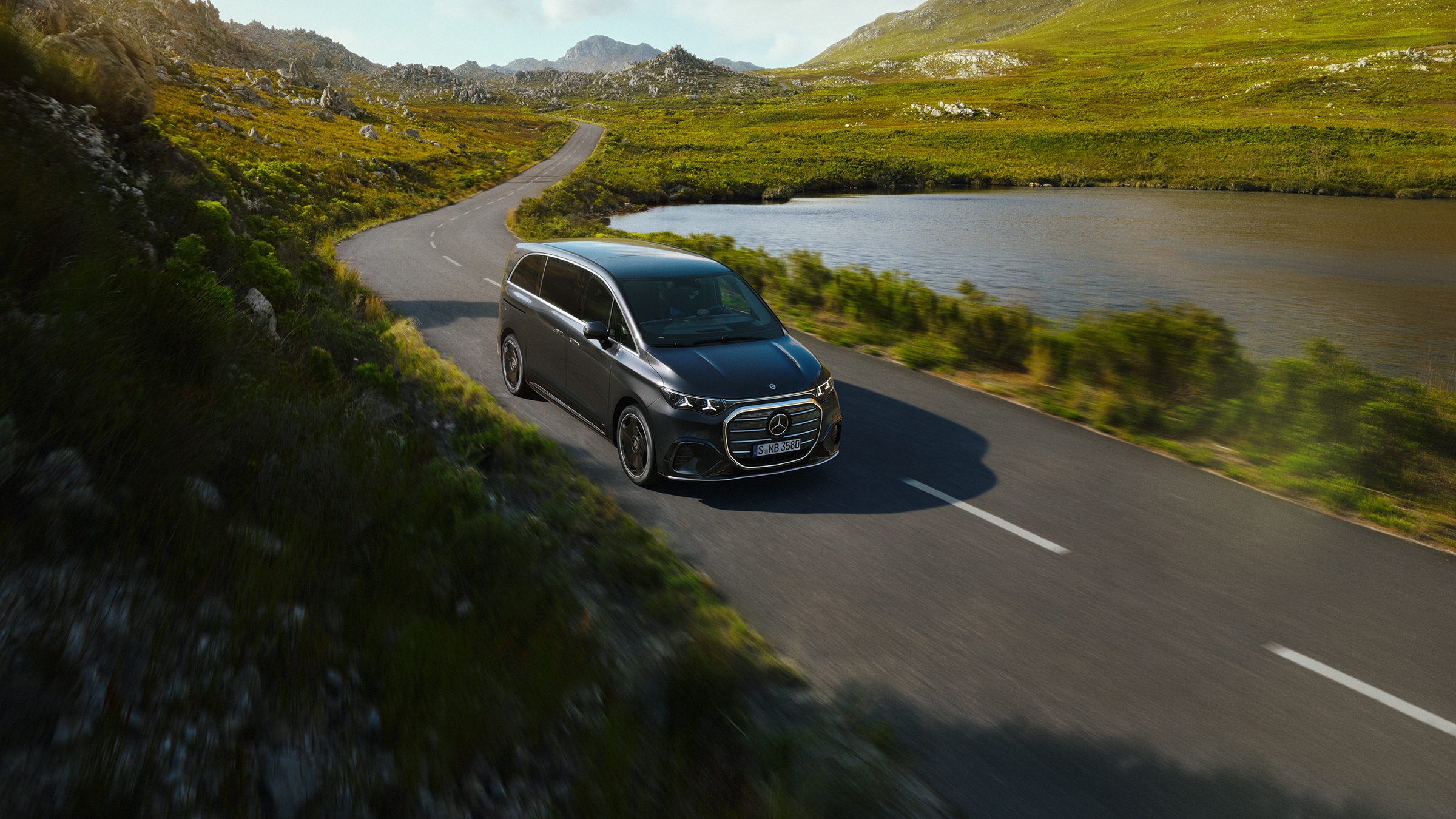 VLE | Modelli di Van e camper | Veicoli commerciali Mercedes-Benz Una Mercedes‑Benz VLE mentre percorre una strada panoramica in riva al lago, mettendo in risalto il comfort di alto livello, la spaziosità e la raffinata versatilità di viaggio.
