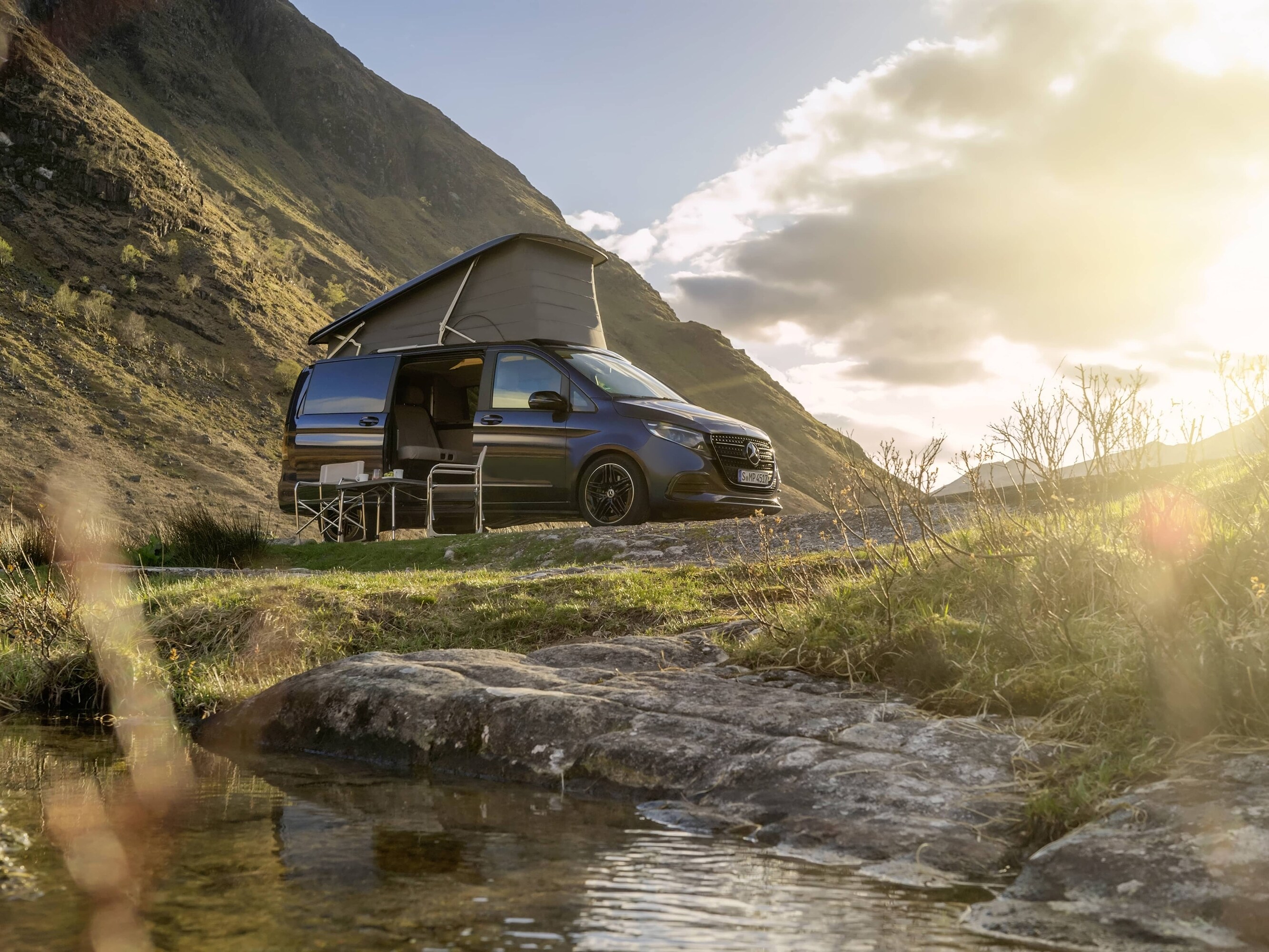 Ein Mercedes-Benz Marco Polo-Wohnmobil mit Aufstelldach inmitten einer malerischen Berglandschaft – ein Symbol für Outdoor-Abenteuer und die Freiheit des „Vanlife“.