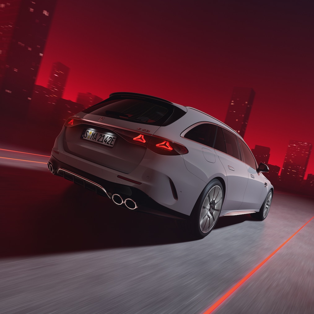 Gros plan sur la jupe arrière AMG en noir avec deux doubles sorties d'échappement rondes en chrome brillant.