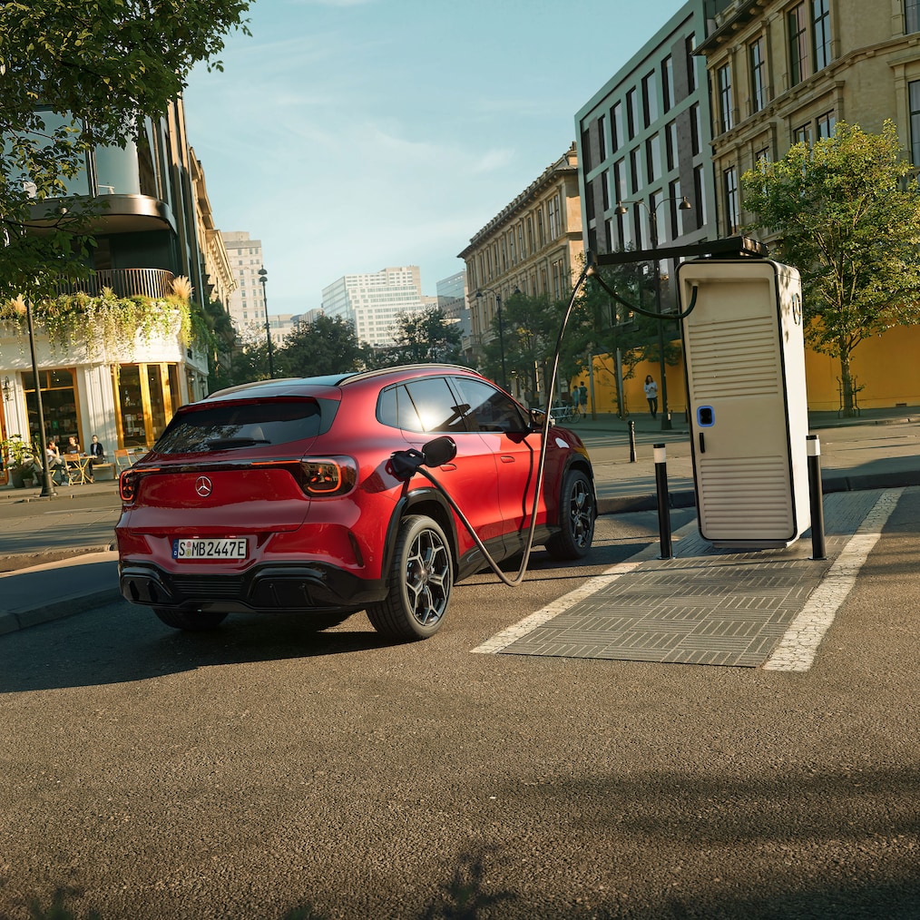 La toute nouvelle Mercedes-Benz GLA électrique garée à une borne de recharge électrique.