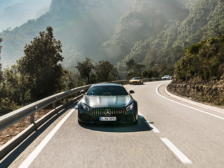 Ein Mercedes-AMG GT R aus einer frontalen Perspektive, fahrend auf einer Straße.