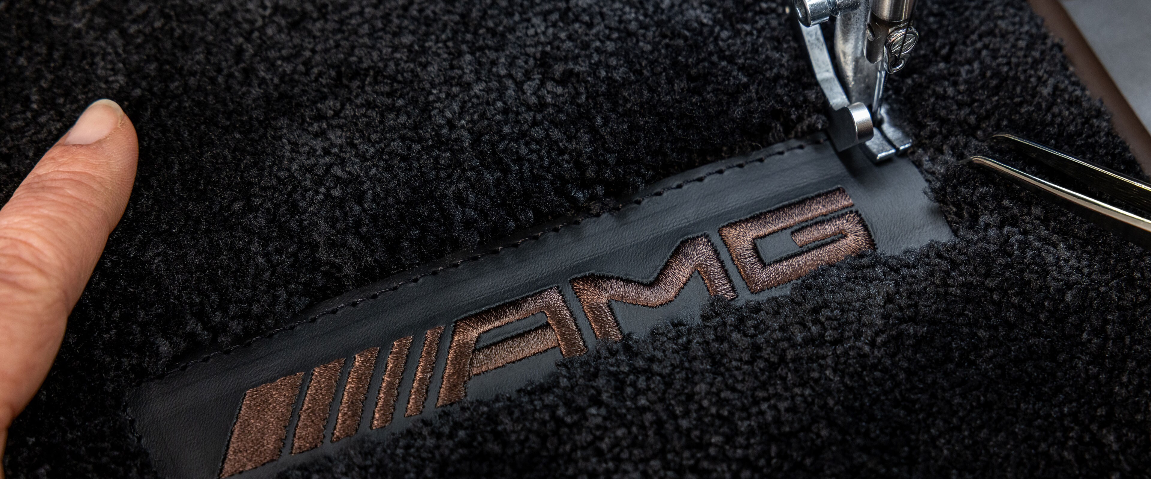 Inscription MANUFAKTUR sur une surface foncée dans une Mercedes-AMG.