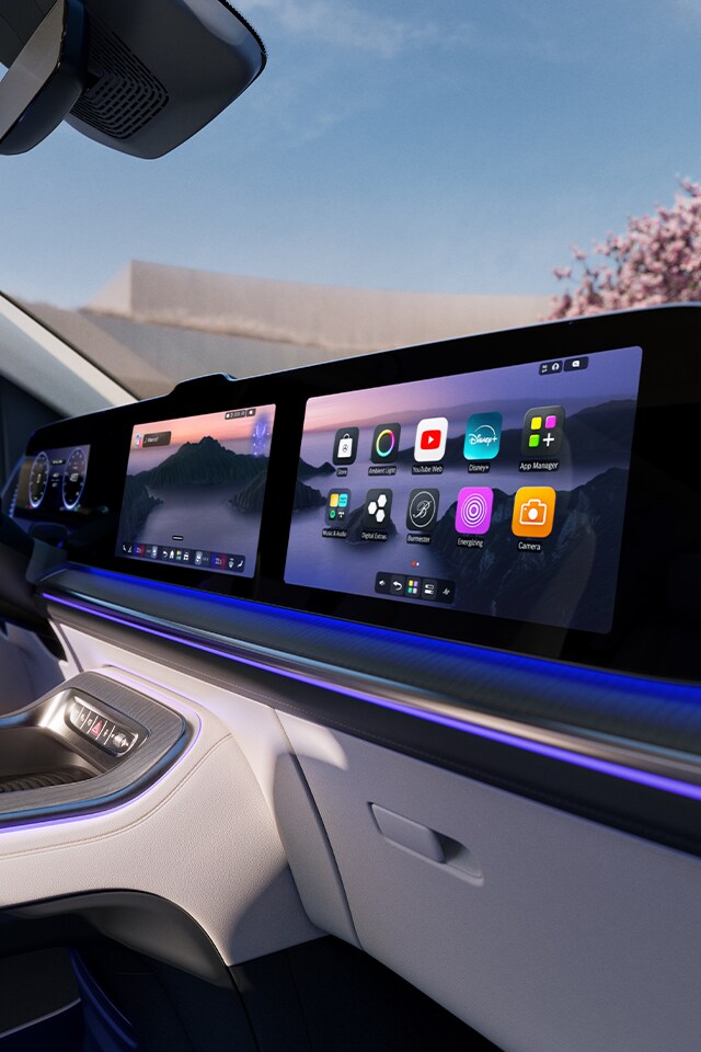 Zu sehen ist das Interieur und das MBUX des VLEs. Im Hintergrund ist ein Kirschbaum zu sehen.