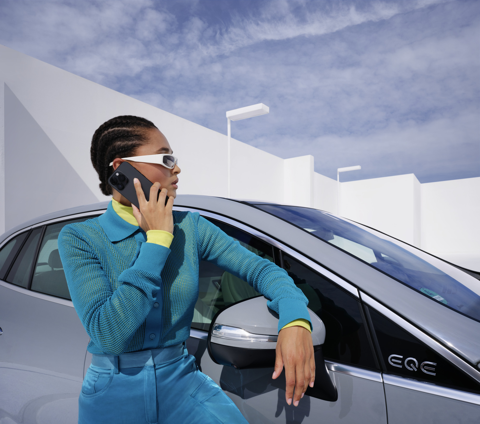 Schaden und Panne | Mercedes-Benz Frau lehnt sich beim Telefonieren an ihren Mercedes-Benz.