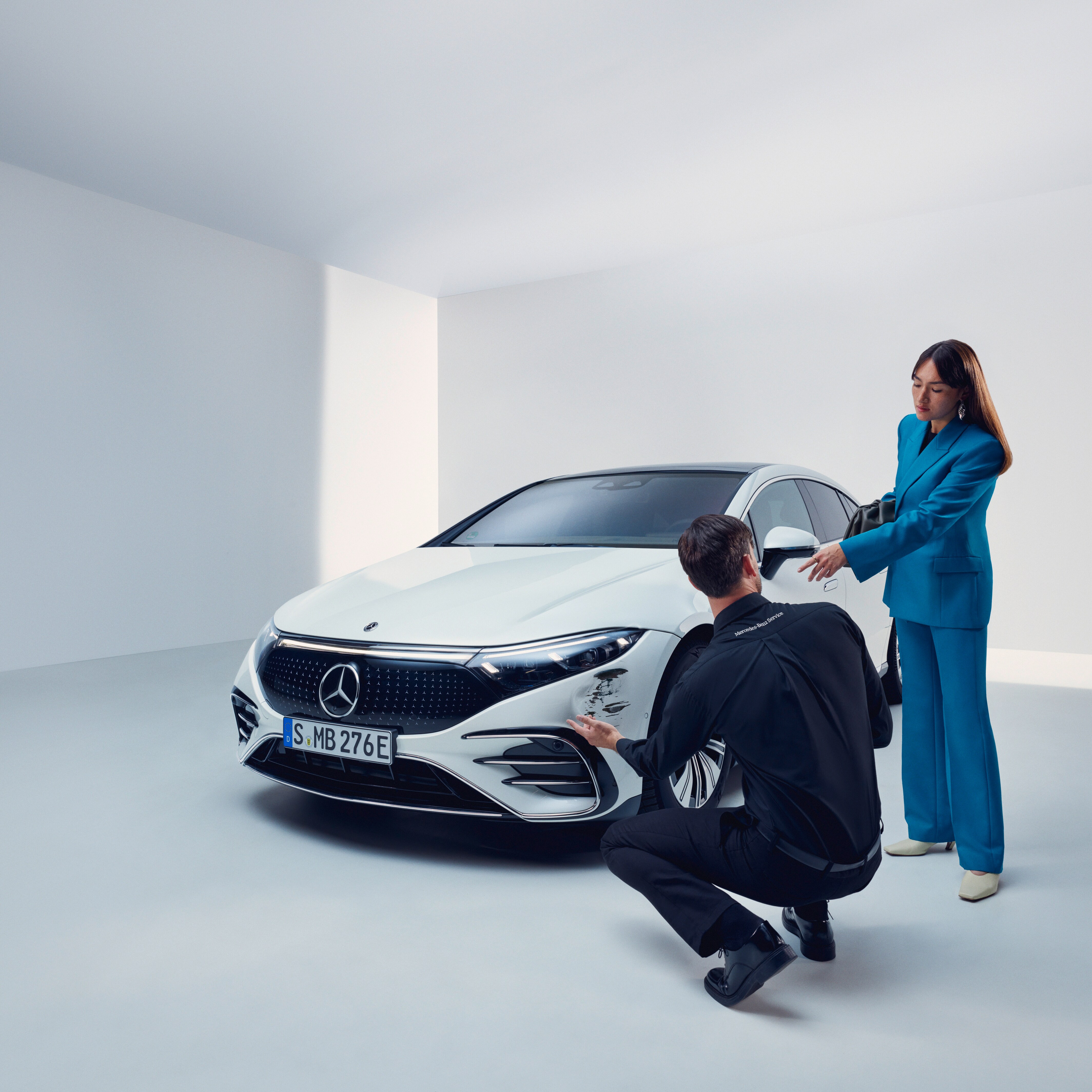 Un uomo ispeziona la Mercedes-Benz di una donna.