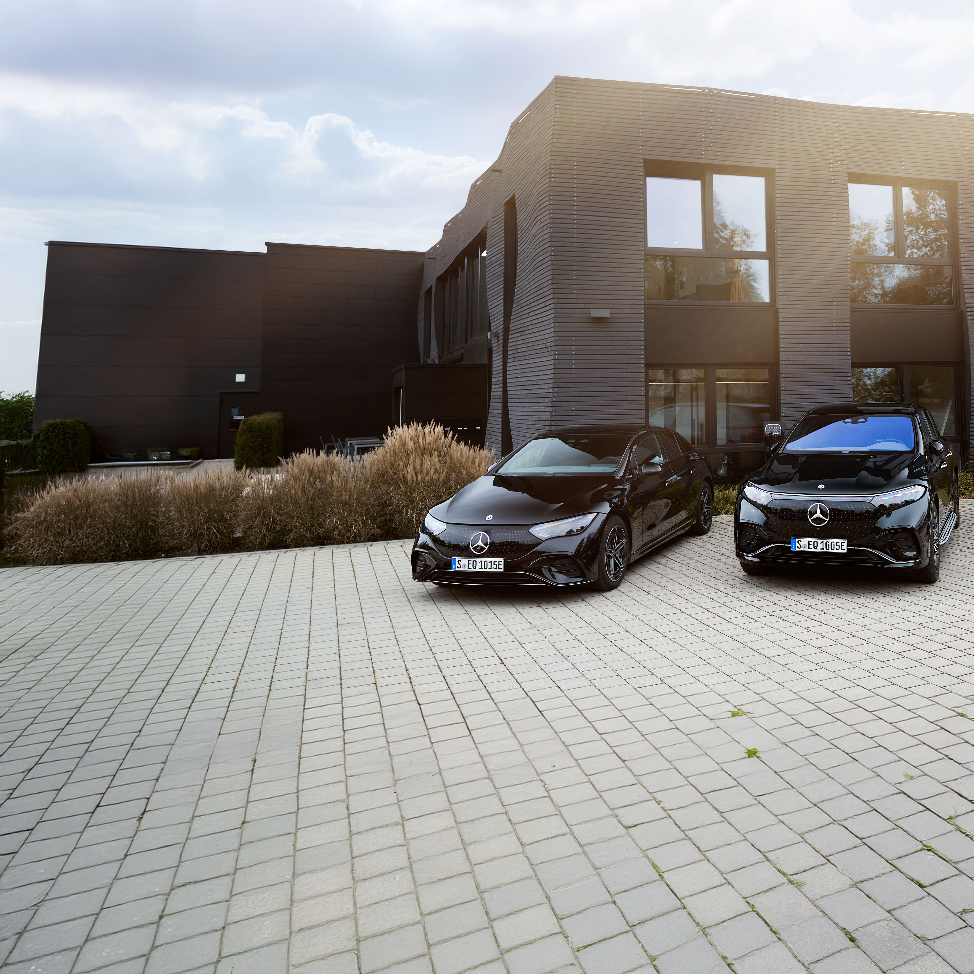 Solutions de recharge pour clients professionnels | Mercedes-Benz Clients professionnels de flottes électriques vérifiant l'état de charge de leur véhicule.