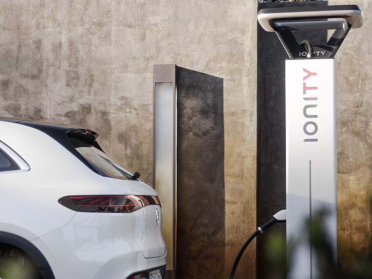 Un homme rechargeant sa Mercedes-Benz électrique à une borne de recharge IONITY.