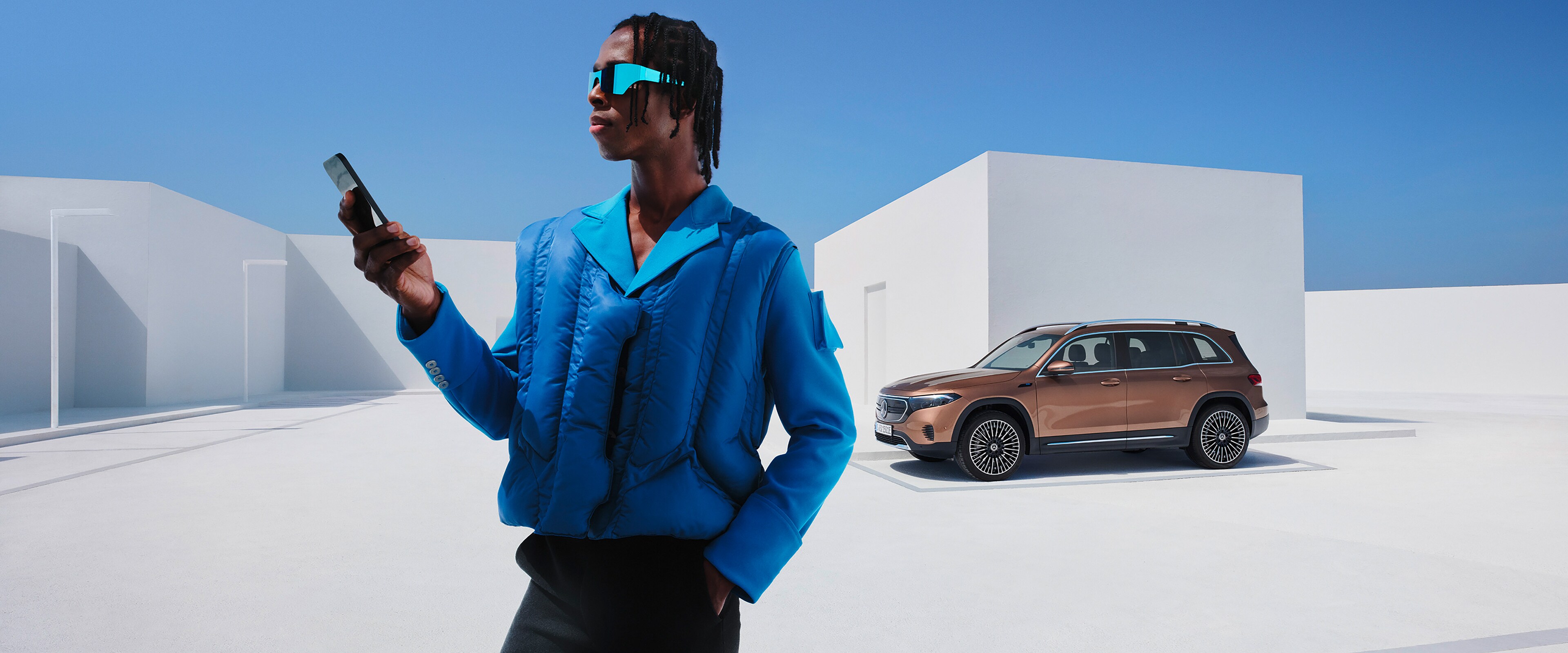 Un uomo è collegato con la sua Mercedes-Benz tramite lo smartphone e i Digital extras.