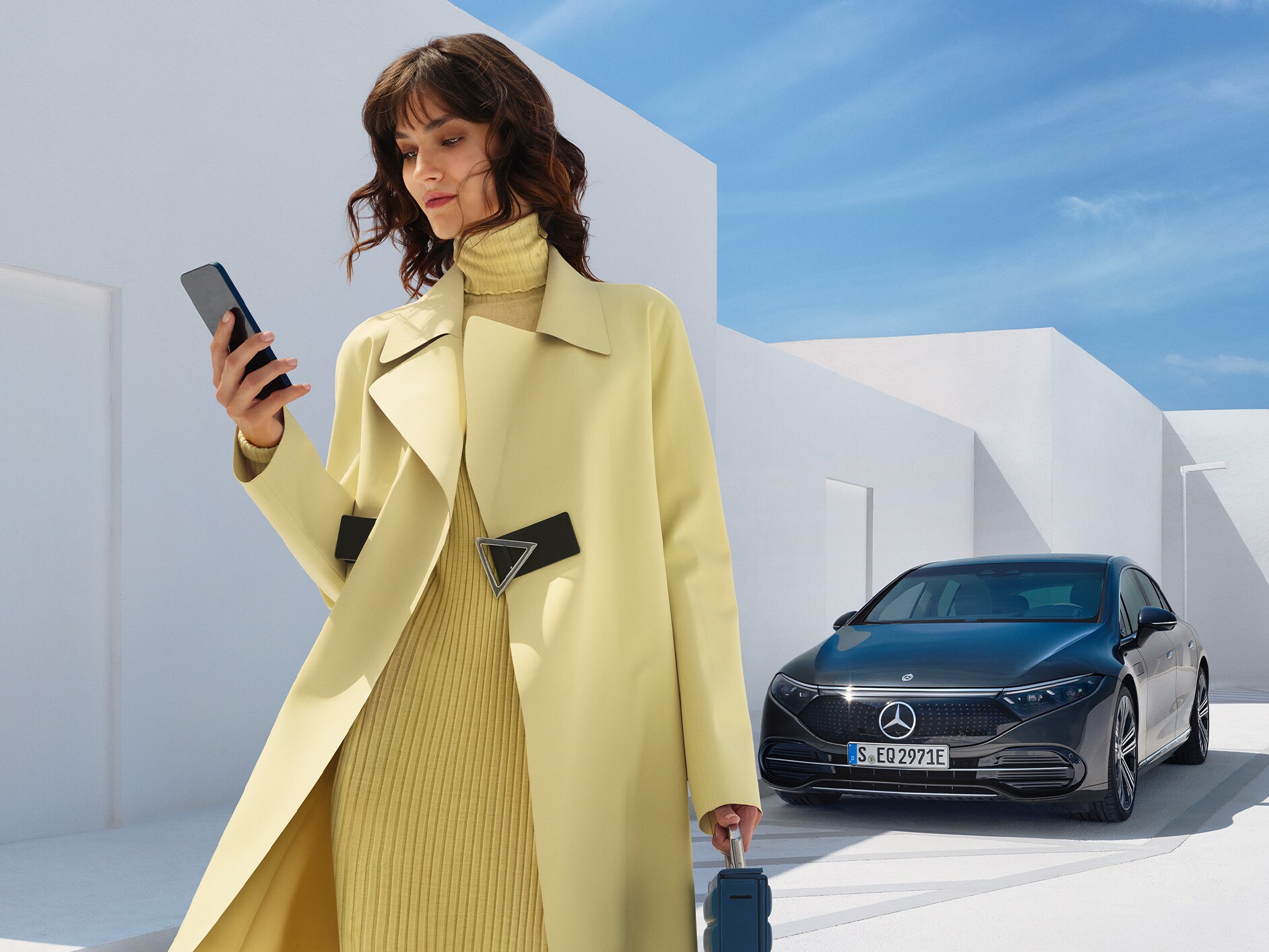 Una donna di fronte alla Mercedes-Benz EQS Berlina.