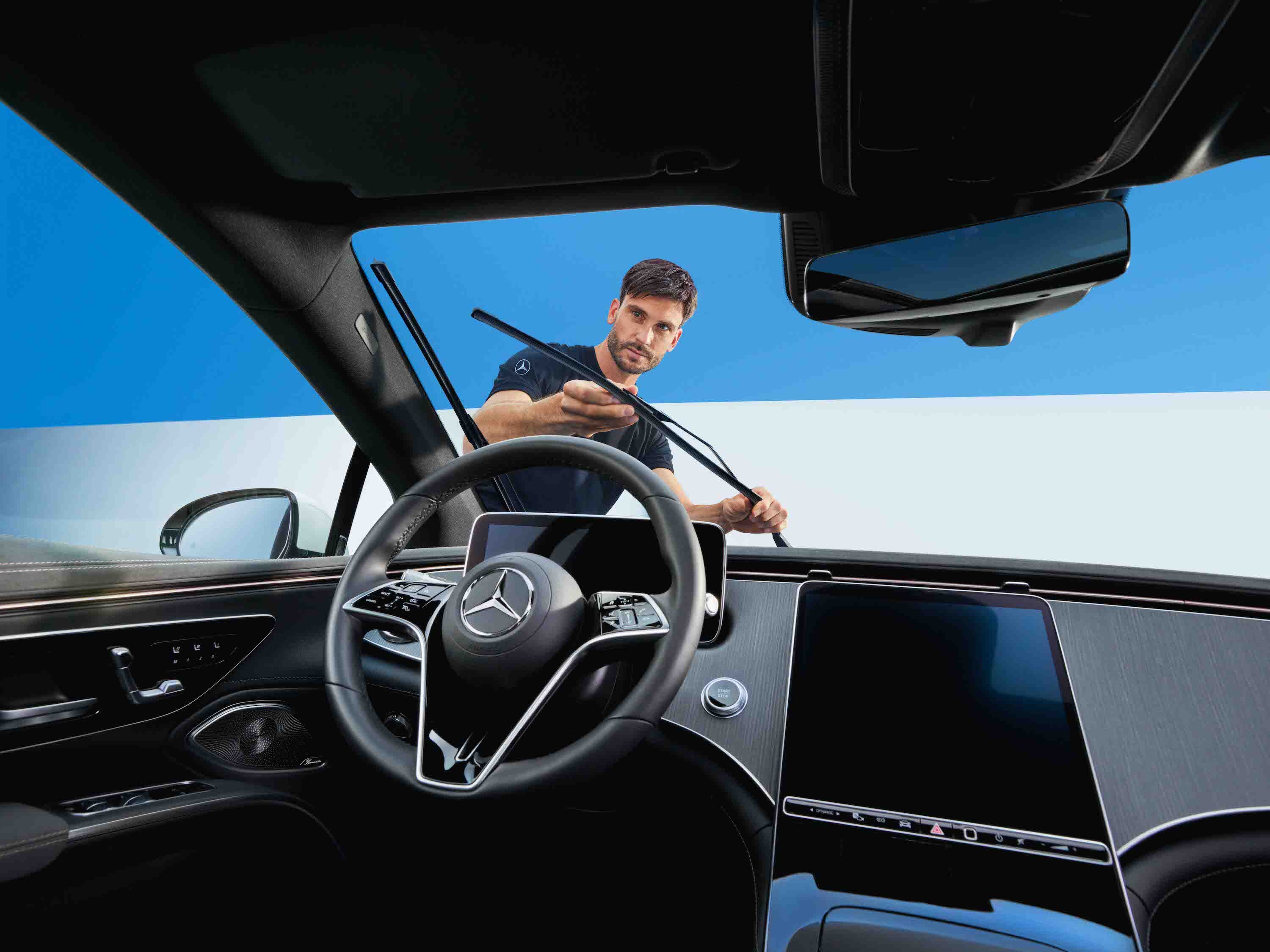 A person adjusting the windscreen wipers of the Mercedes-Benz vehicle.
