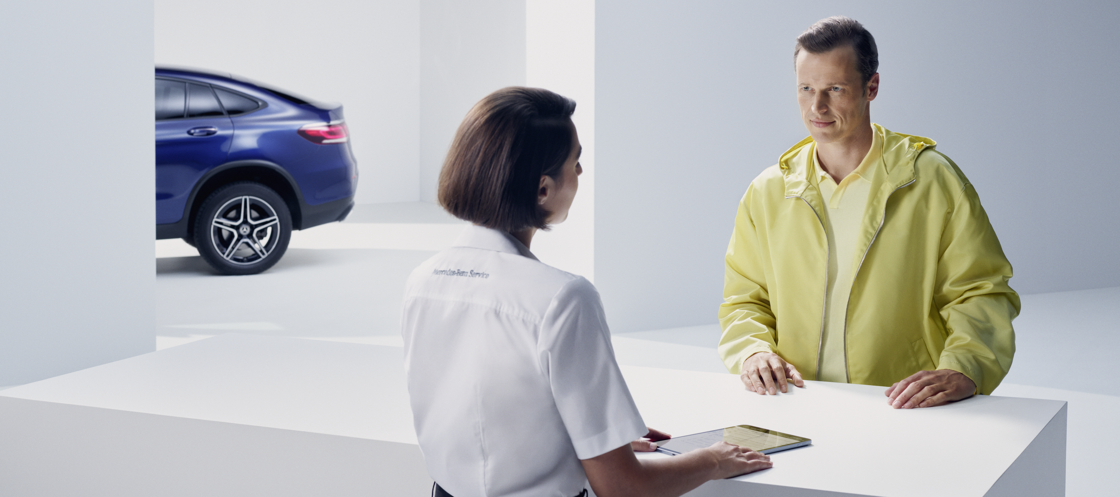 Richiamo di Mercedes-Benz | Mercedes-Benz Cliente al bancone con un'addetta Mercedes-Benz.
