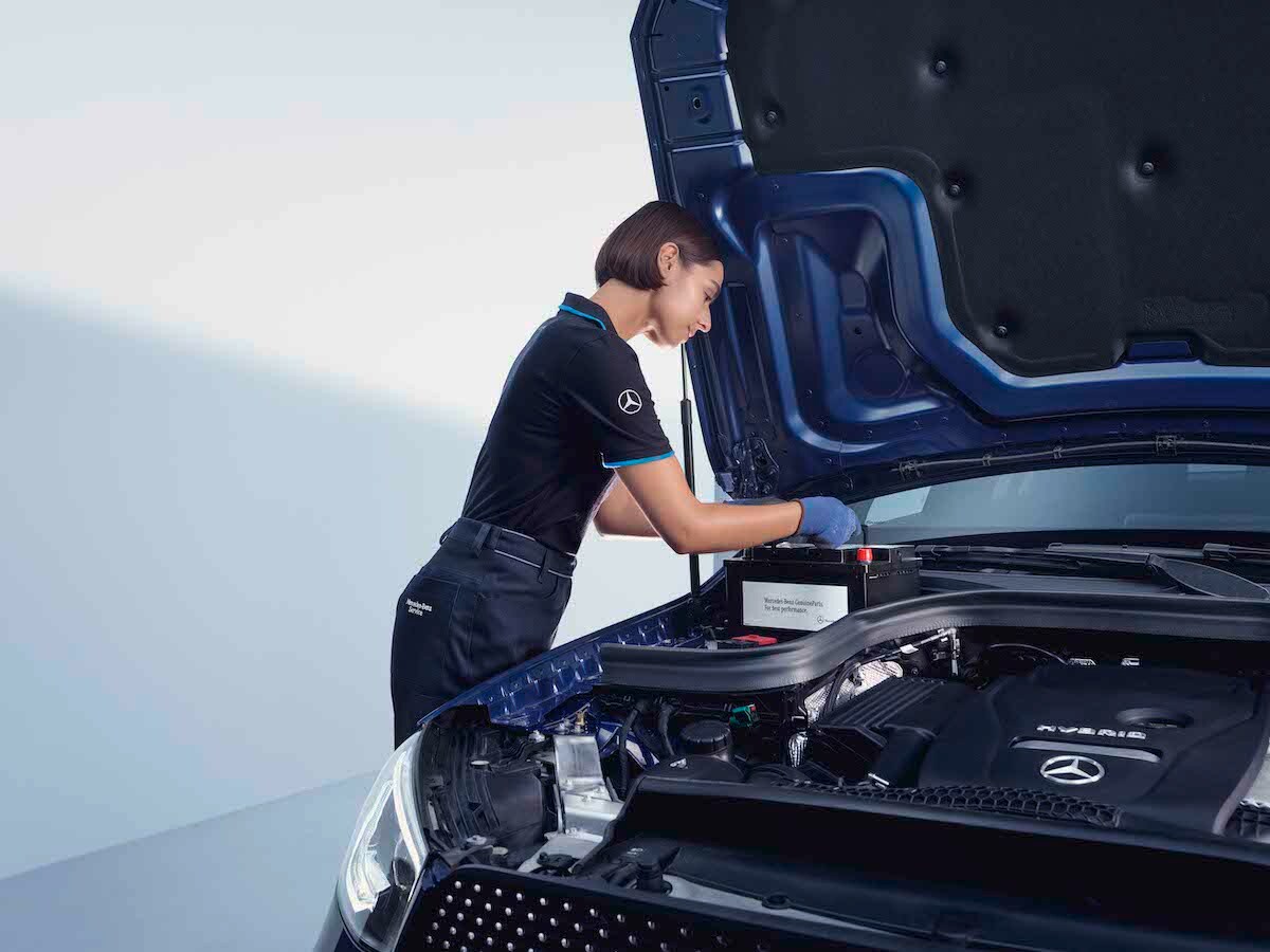 EIne Mercedes-Benz Technikerin überprüft eine Autobatterie.