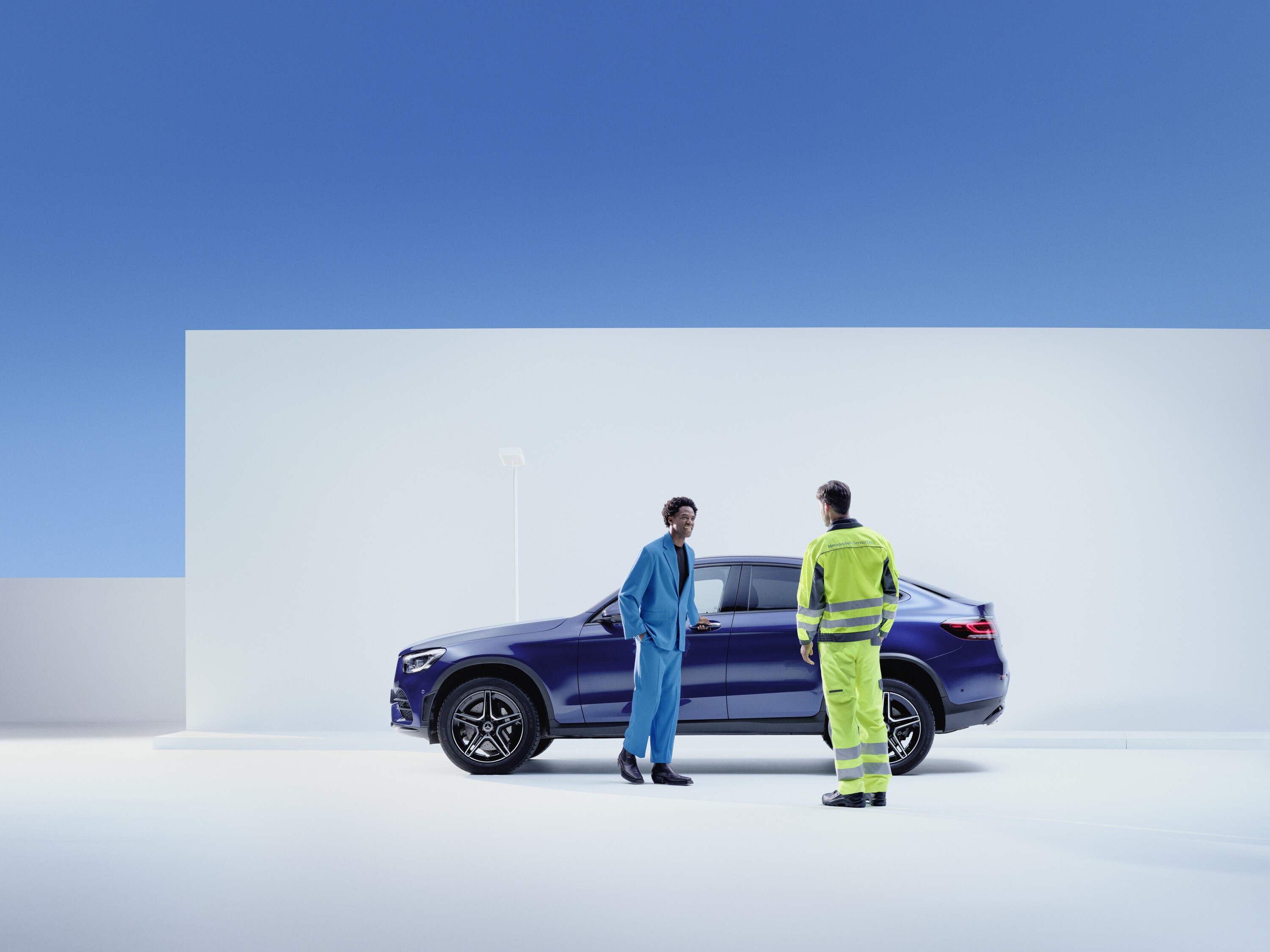 Technicien Mercedes-Benz et client près du véhicule.