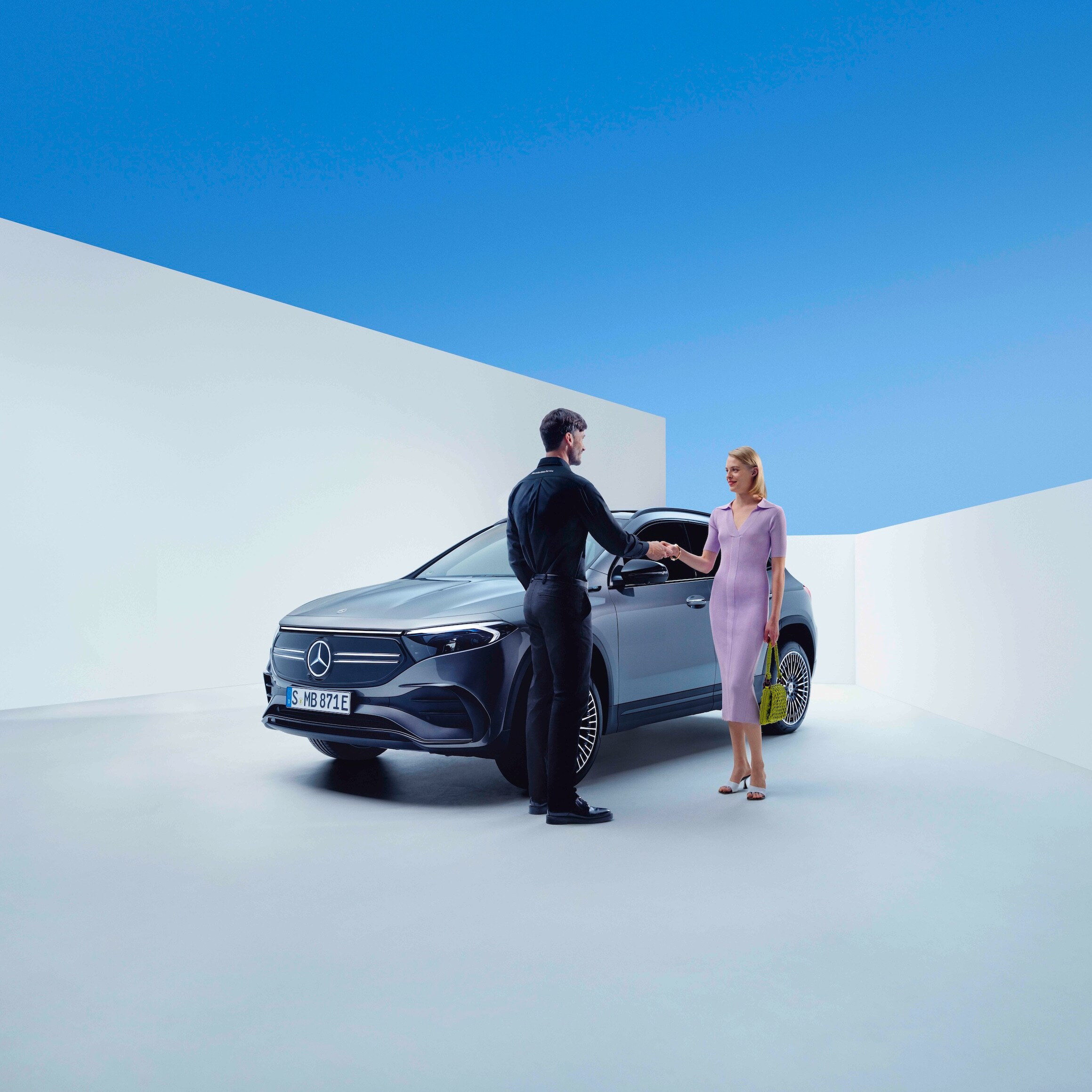 Employé Mercedes-Benz et cliente se serrent la main.