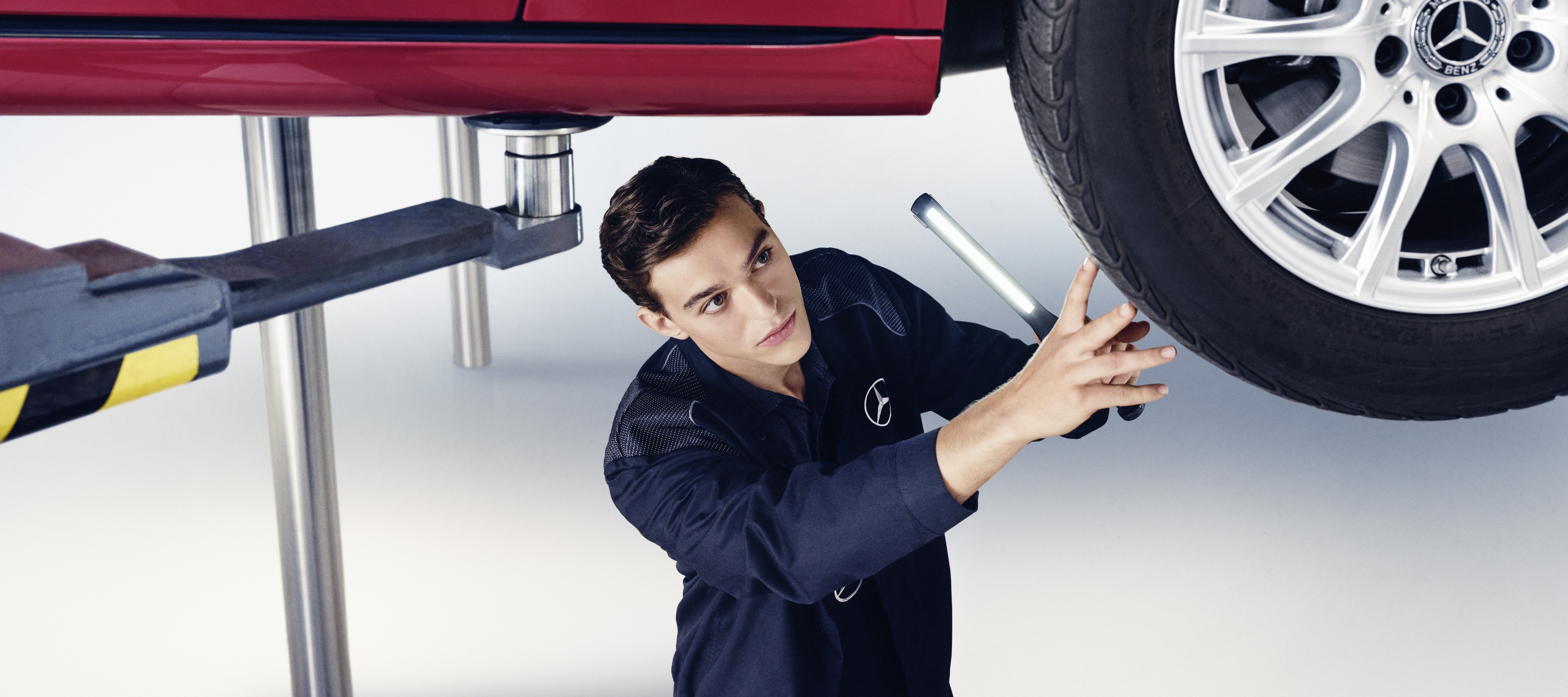 Hauptuntersuchung | Mercedes-Benz Ein Mann inspiziert einen Mercedes Benz.