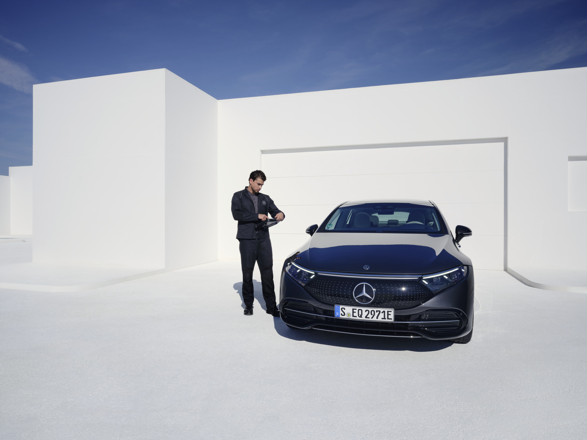 Maintenance des véhicules électriques | Mercedes-Benz Un technicien Mercedes-Benz inspecte une Mercedes-Benz.