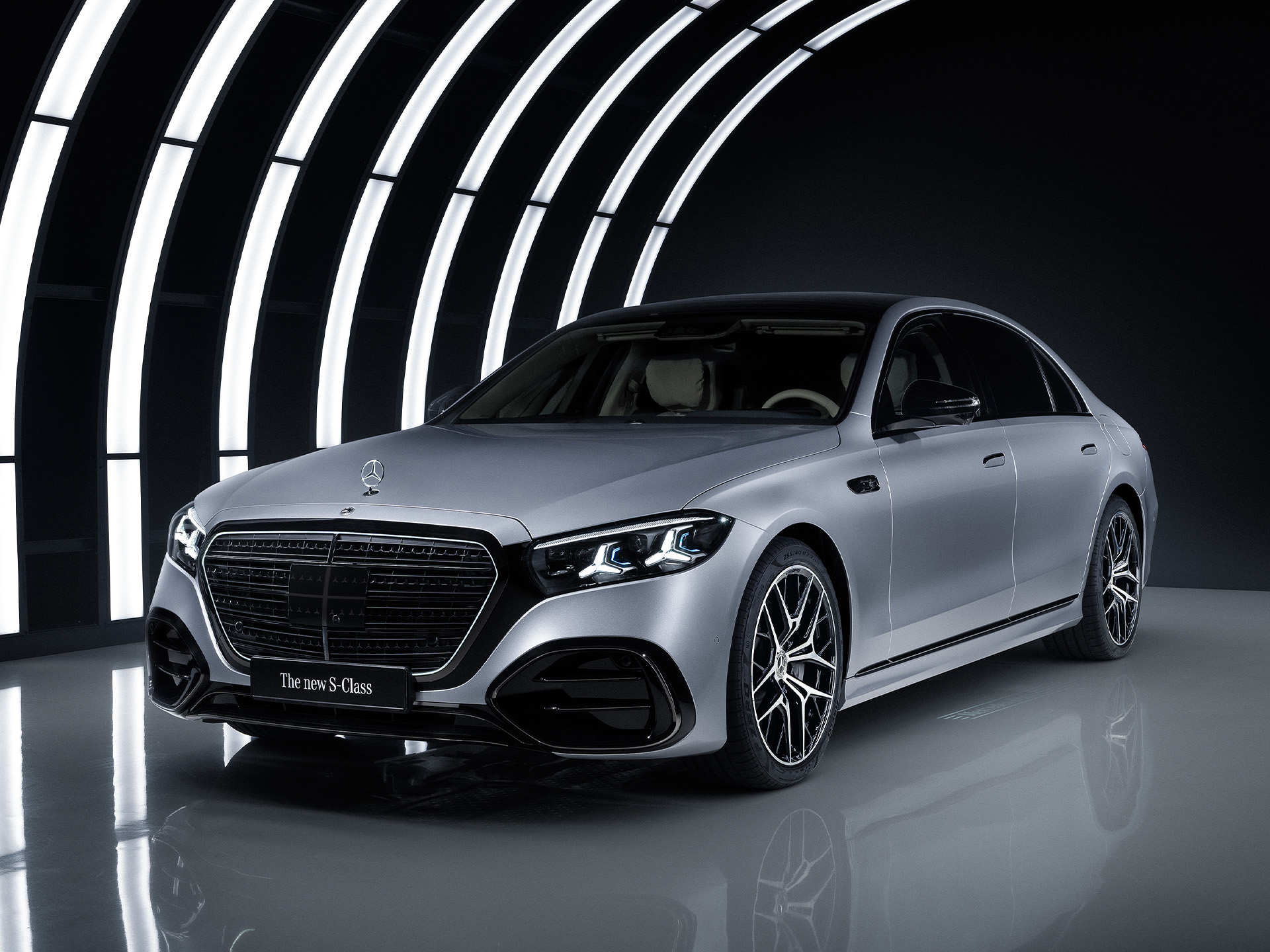 Technologie | Mises à jour logicielles « over-the-air » (OTA) | Mercedes-Benz La Mercedes-Benz Classe S dans un studio, sous un arc lumineux.