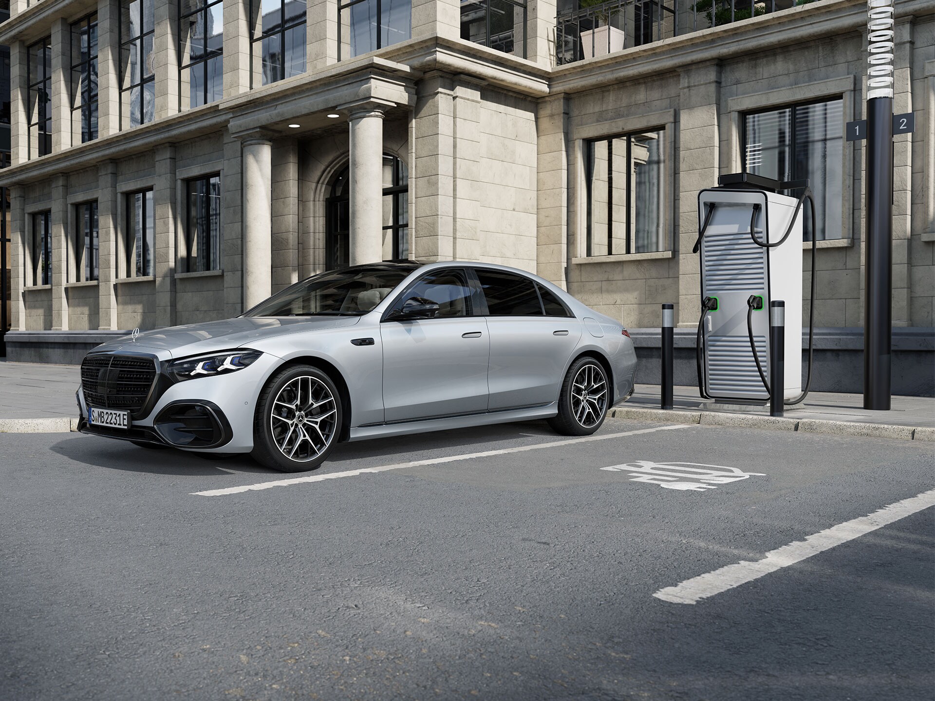 Der Mercedes-Benz S-Klasse Limousine Plug-in-Hybrid mit langem Radstand in einer 7/8-Seitenansicht, der auf einem Parkplatz neben einer Ladestation steht.