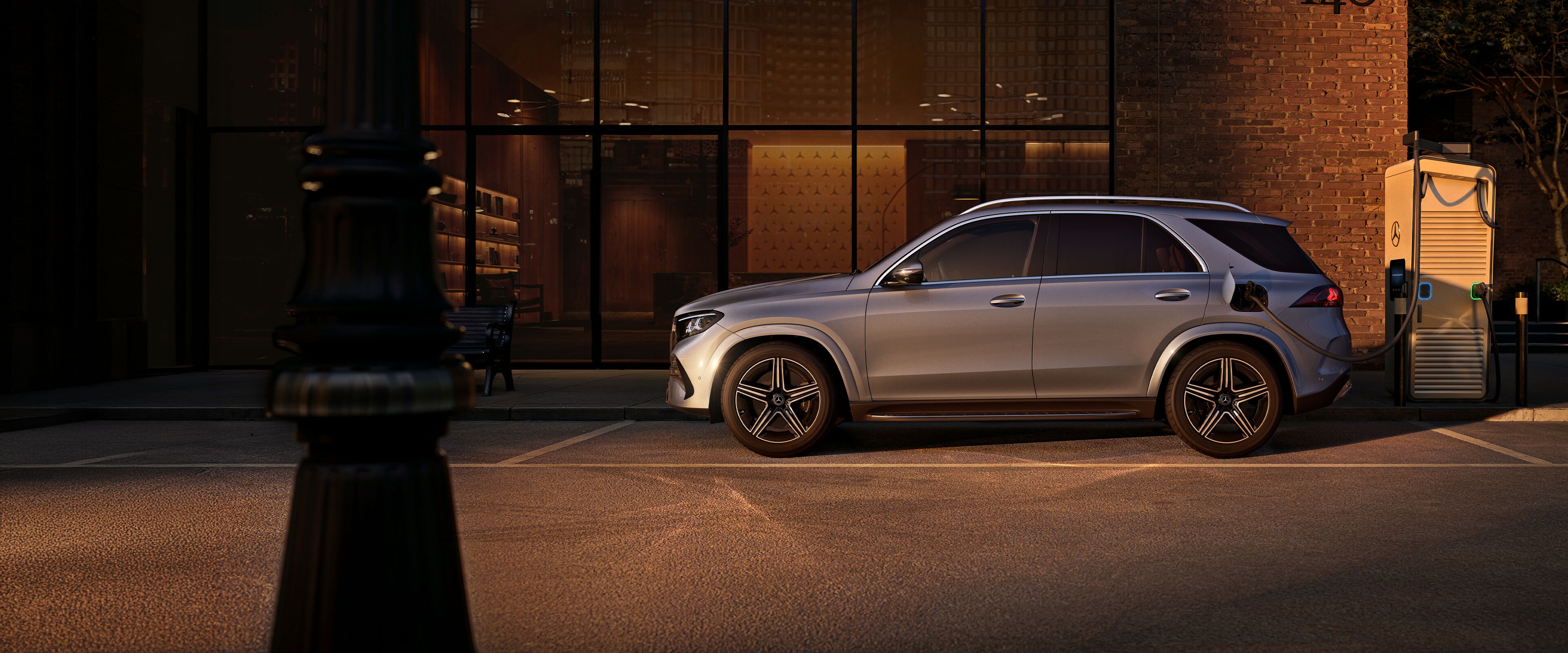 Der Mercedes-Benz GLE SUV in einer Seitenansicht vor einem grossen Haus.
