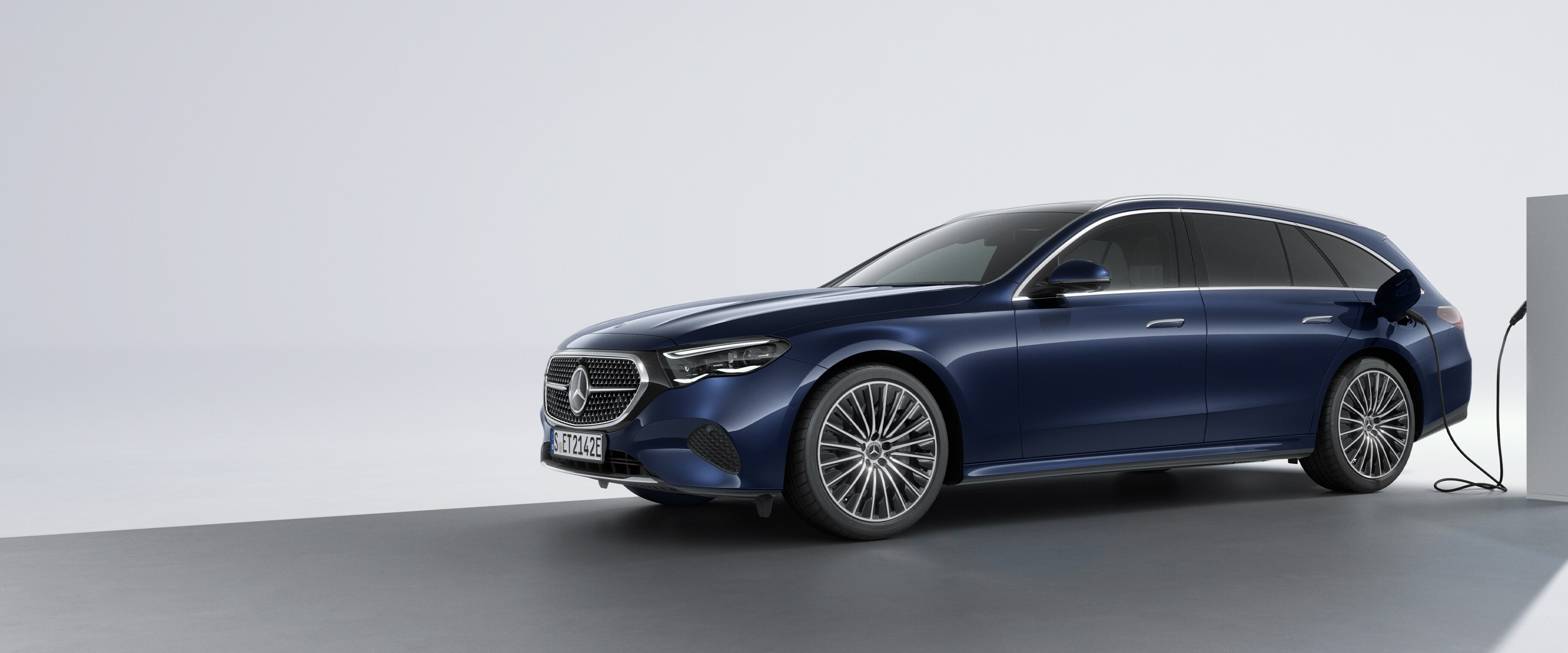 Ein Plug-in-Hybridfahrzeug von Mercedes-Benz in schräger Rückansicht an einer Ladestation.