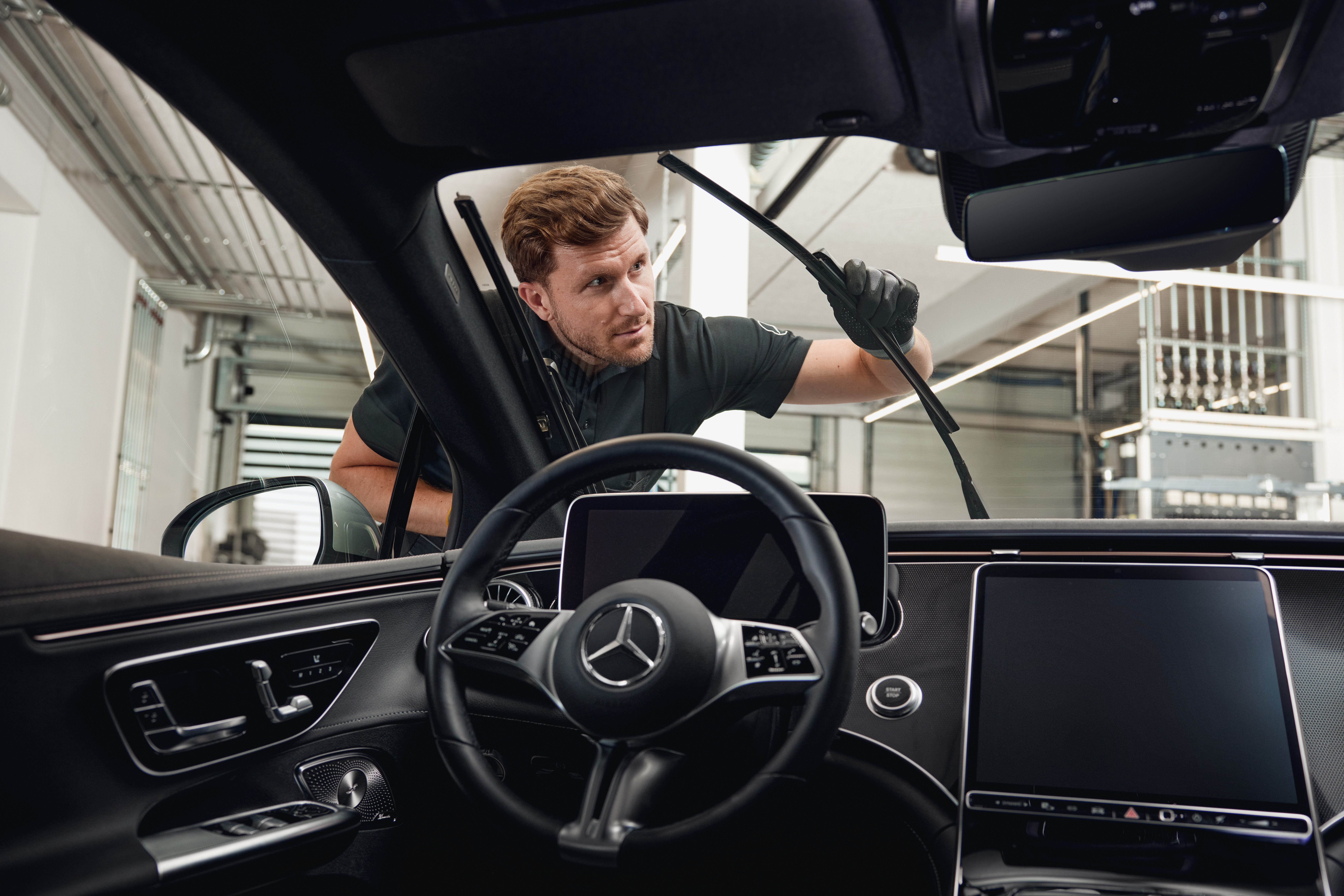 Balais d'essuie-glace d'origine Mercedes-Benz Vue intérieure d'un véhicule Mercedes-Benz avec un technicien remplaçant des balais d'essuie-glace d'origine.