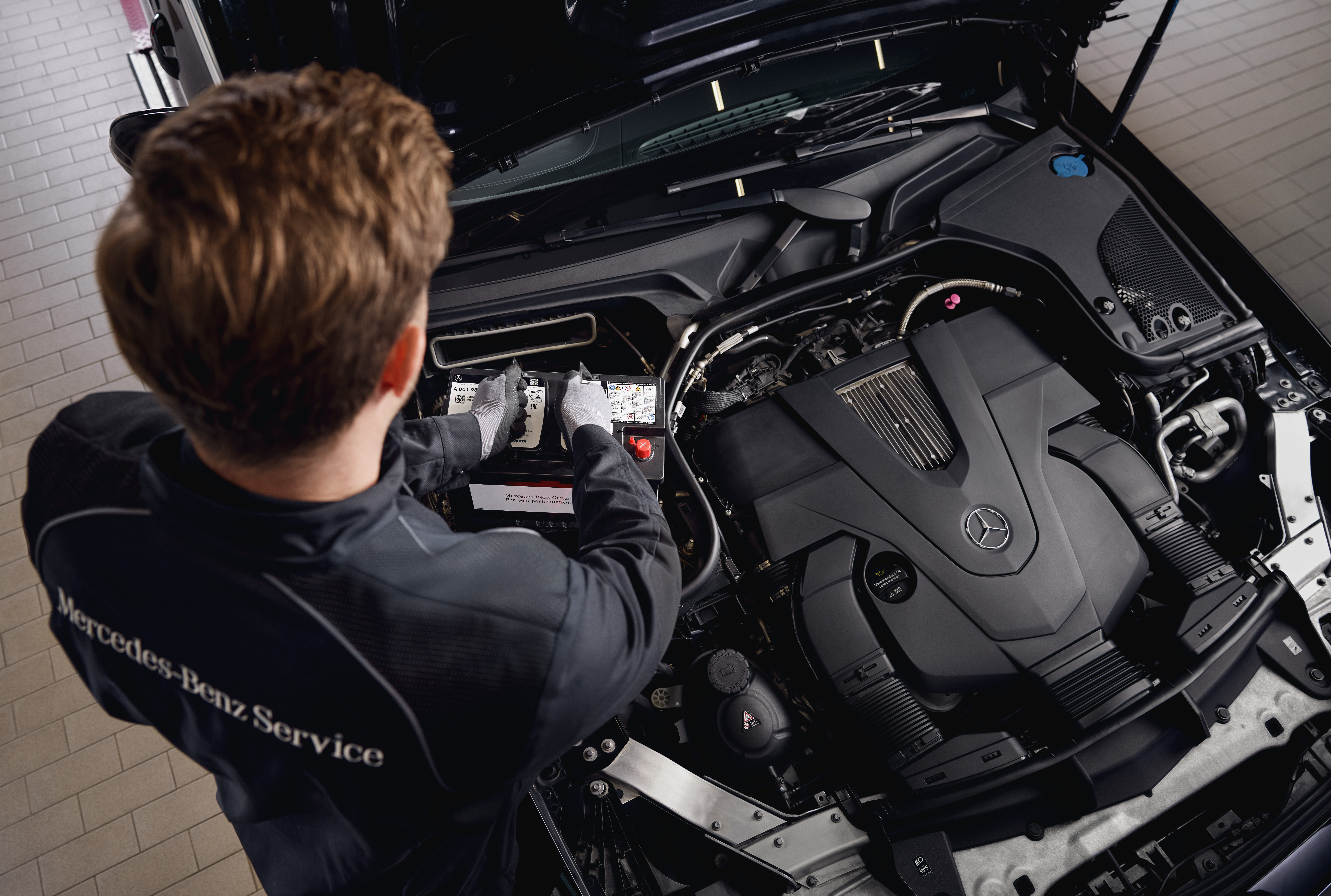 Batteries de démarrage d'origine Mercedes-Benz Maintenance du moteur en atelier, montrant le remplacement de composants par des pièces d'origine Mercedes-Benz.