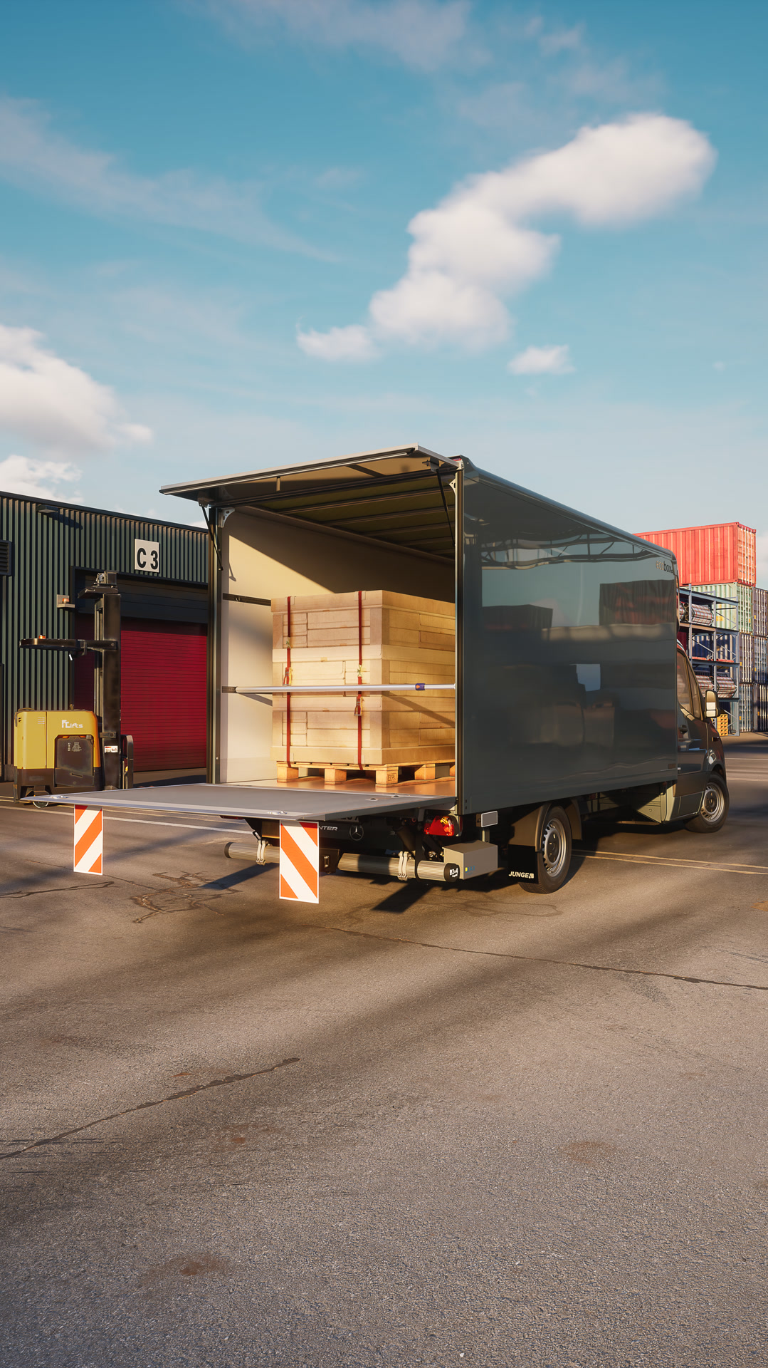 Mercedes-Benz Sprinter mit Trockenfrachtkofferaufbau von Junge beim Beladen in einem Logistikzentrum – eine effiziente Transportlösung für Stückgut und den Warenumschlag. Die geöffnete Hecktür gibt den Blick auf die auf Paletten gestapelten Holzplatten im Laderaum während des Be- oder Entladens frei.