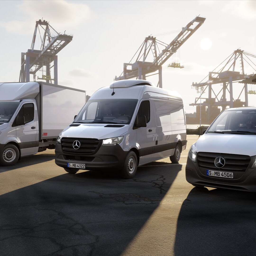 Tre veicoli commerciali Mercedes-Benz posizionati in un terminal per container di fronte alle gru portuali. Sono visibili un veicolo con sovrastruttura, un furgone e un van compatto in un contesto logistico.
