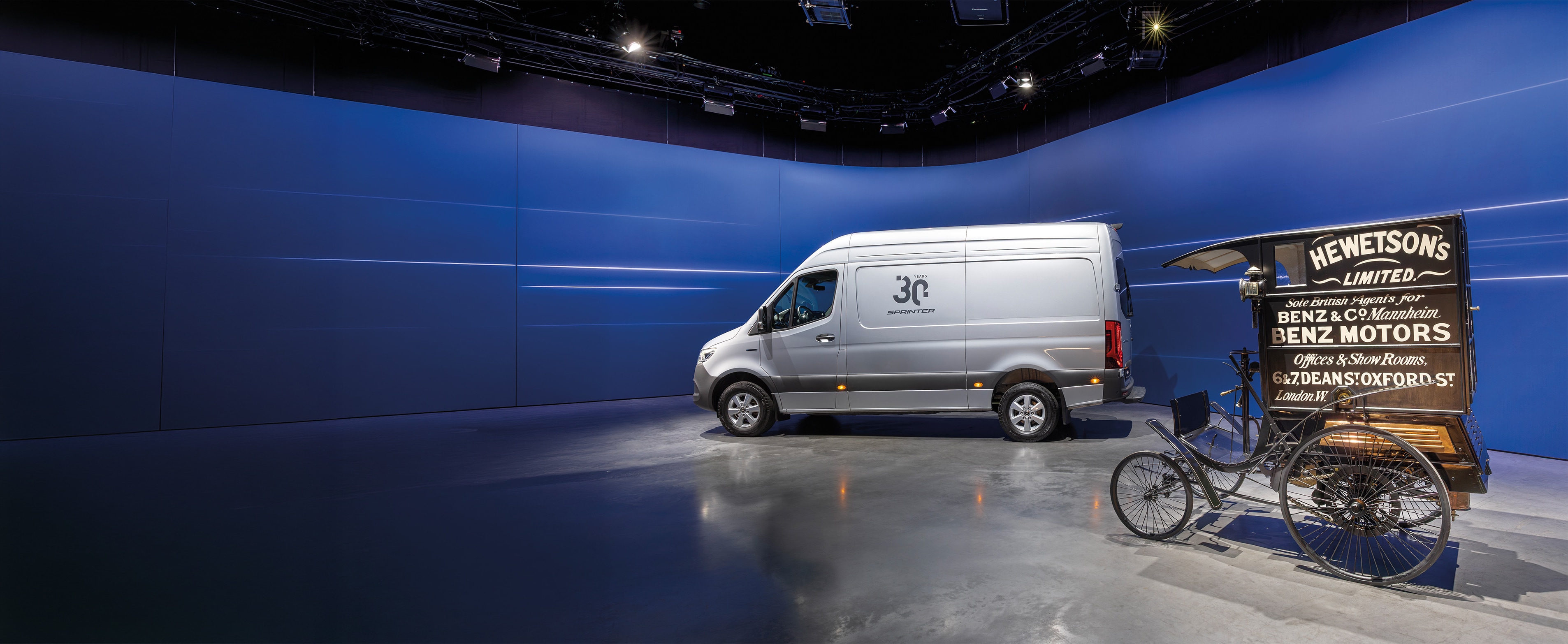 Storia | Veicoli commerciali | Mercedes-Benz Un veicolo commerciale Mercedes-Benz Sprinter e un veicolo commerciale storico Benz esposti in un moderno showroom