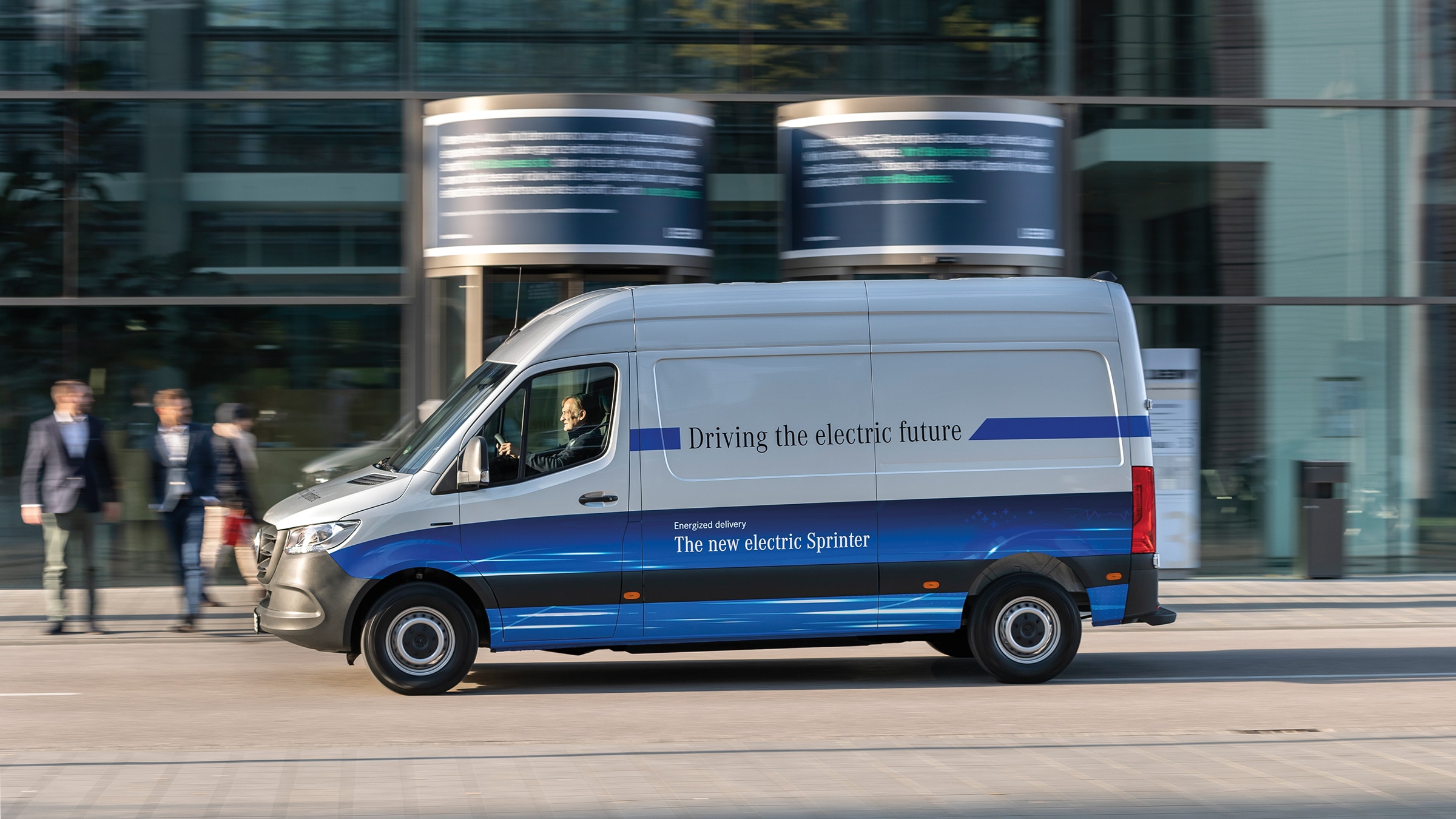 L'eSprinter Fourgon de deuxième génération | Histoire des véhicules industriels | Mercedes-Benz Un fourgon de livraison Mercedes-Benz eSprinter circulant dans les rues d'une ville moderne