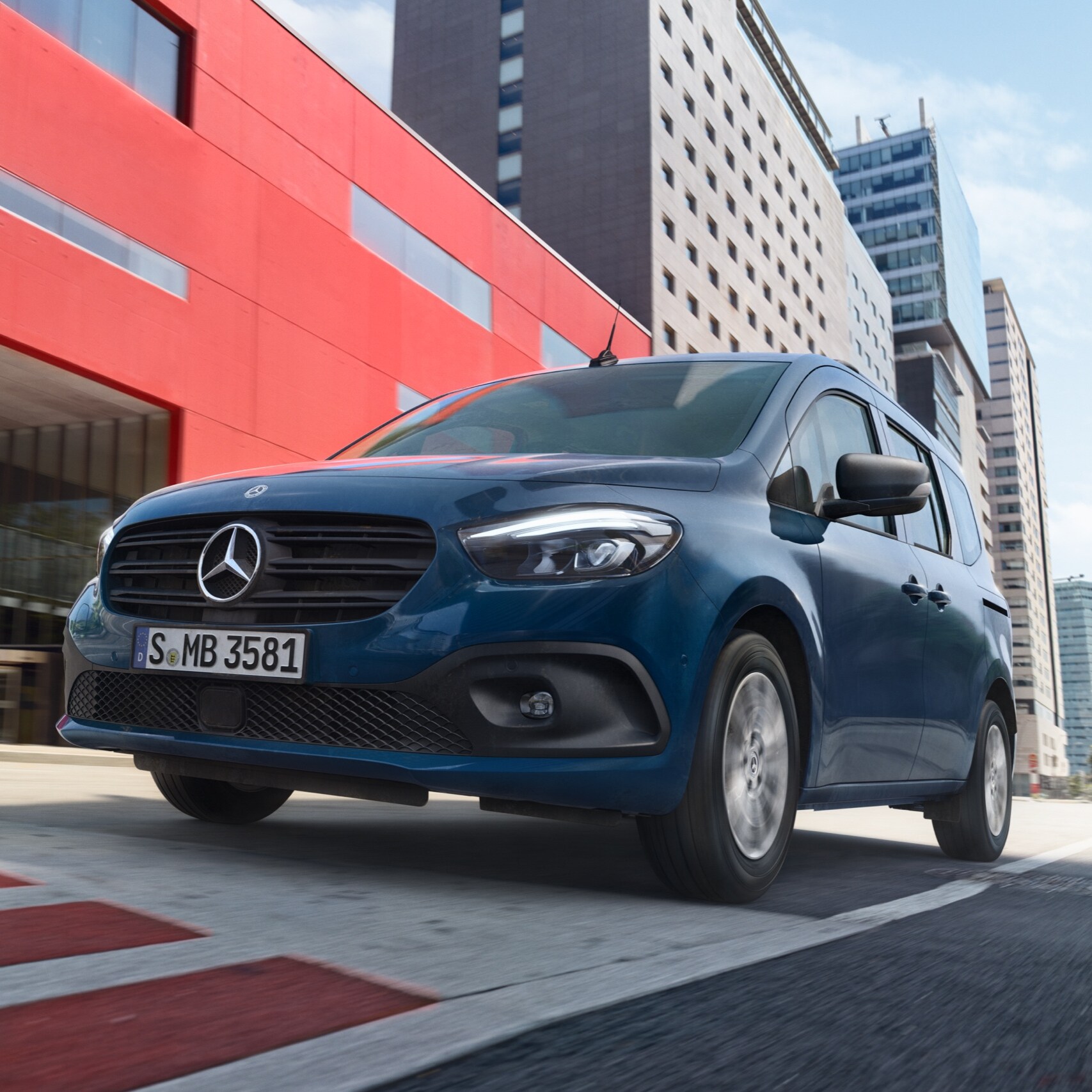 L'eCitan Tourer, un monospace électrique de Mercedes-Benz pour transporter des personnes, roule dans un environnement urbain moderne.