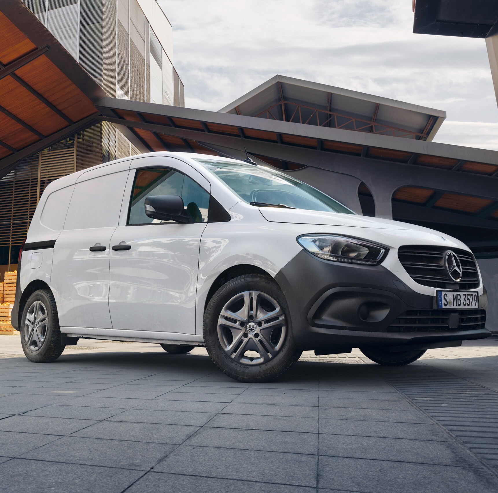 Le Mercedes-Benz Citan fourgon en ville devant le mur d'une maison.