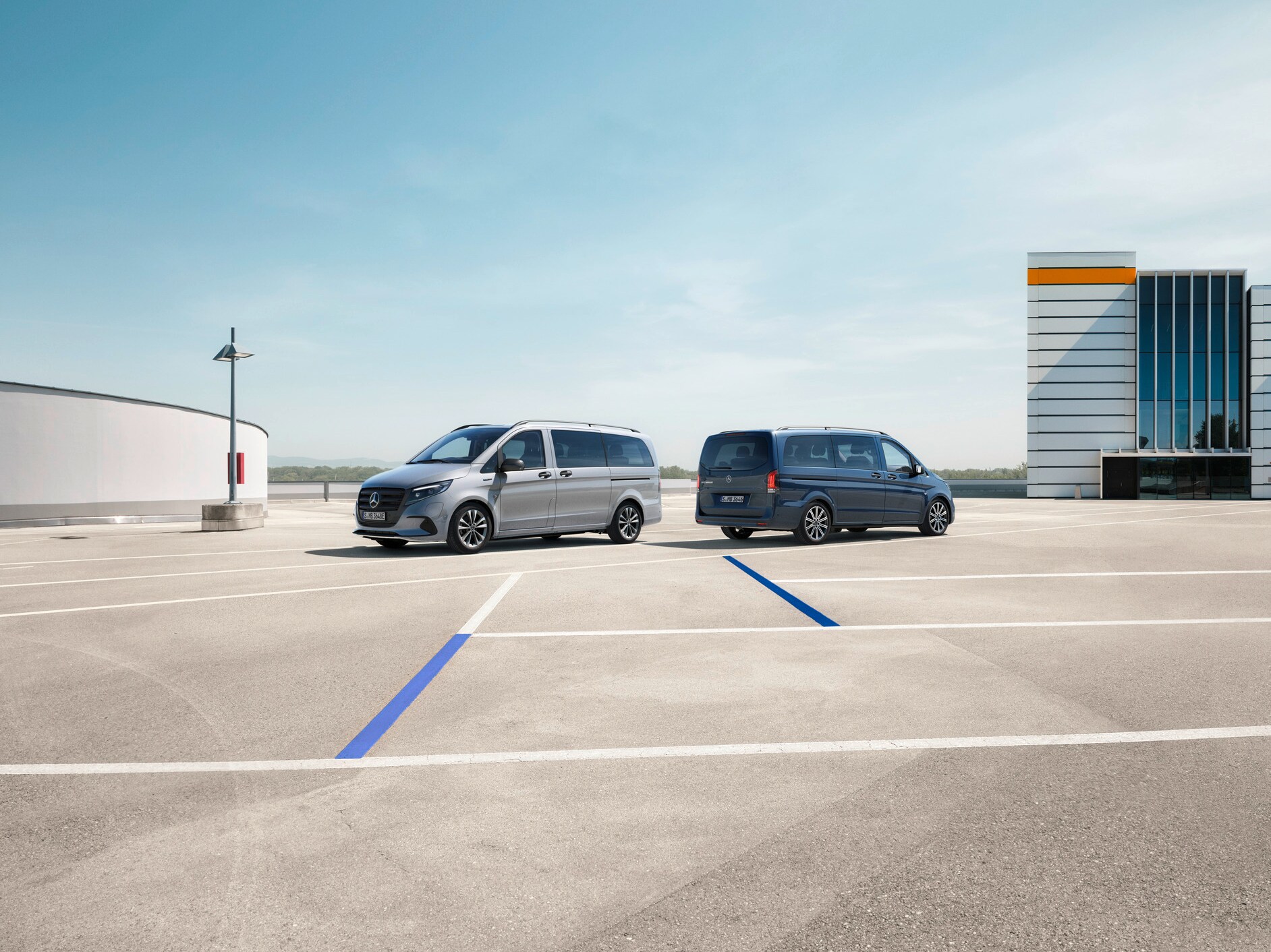 Der eVito Tourer und Vito Tourer stehen auf einem Parkplatz.