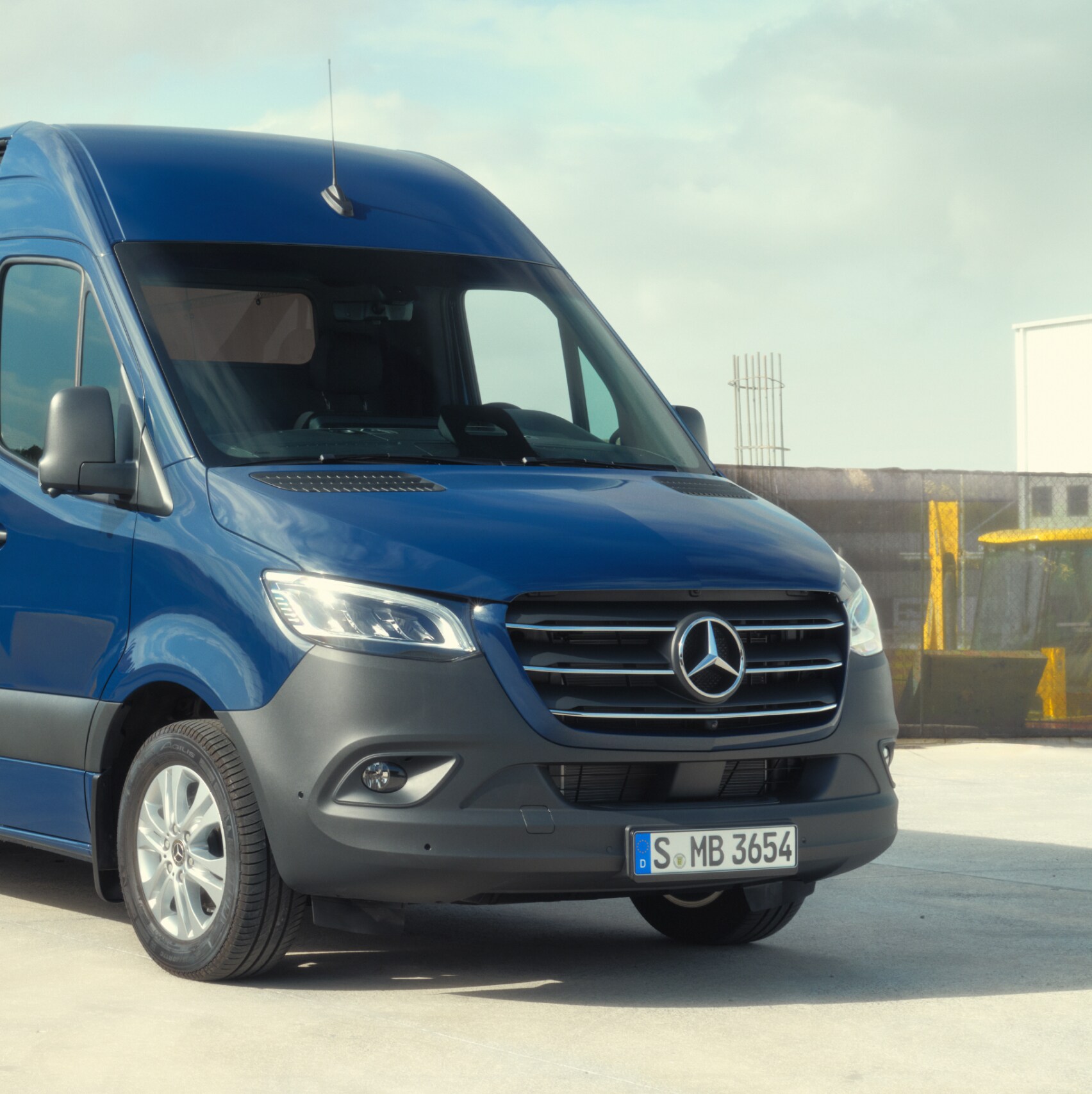La Mercedes-Benz Sprinter fourgon devant des matériaux de construction.