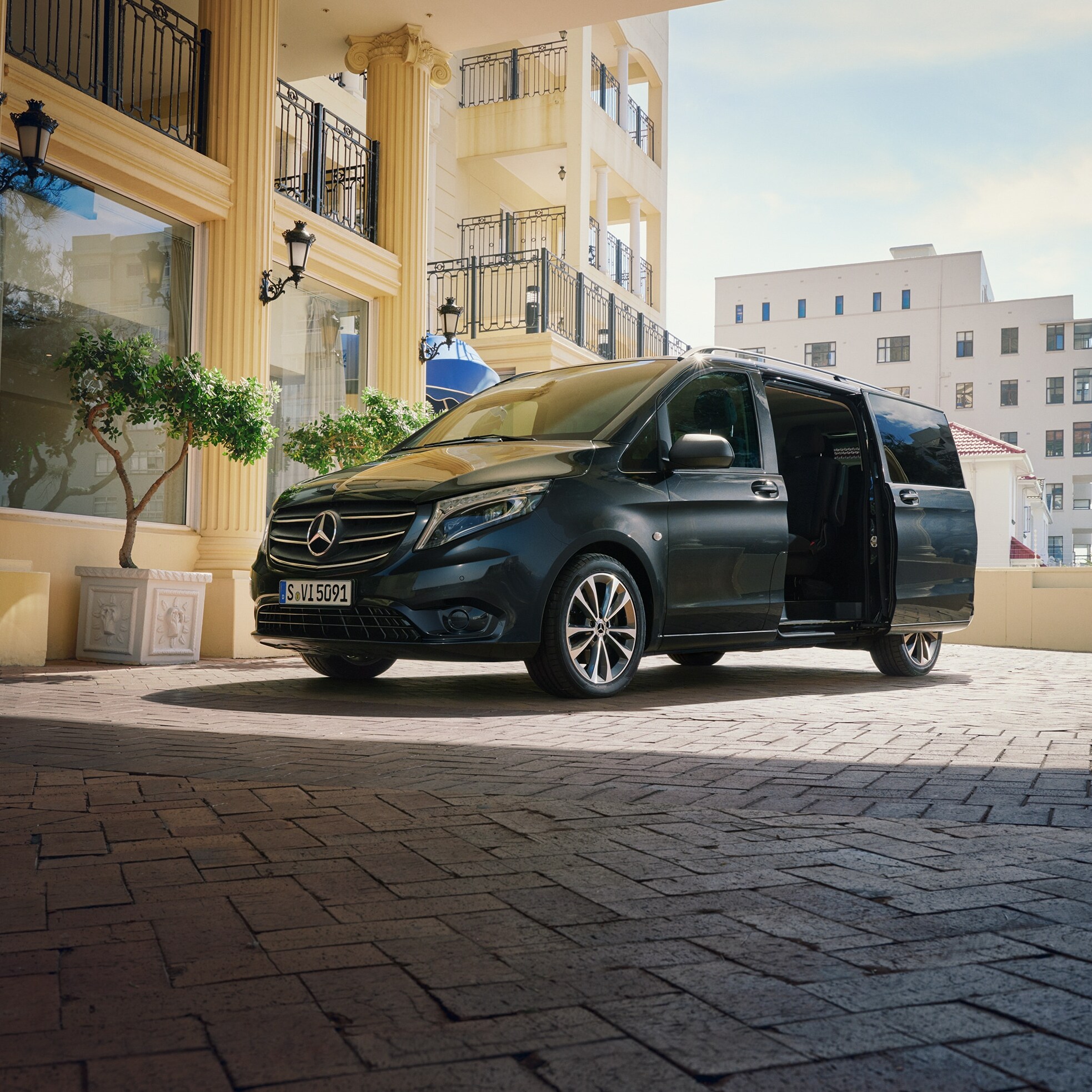 Un Mercedes‑Benz Vito Tourer parcheggiati all’ingresso di un edificio di lusso