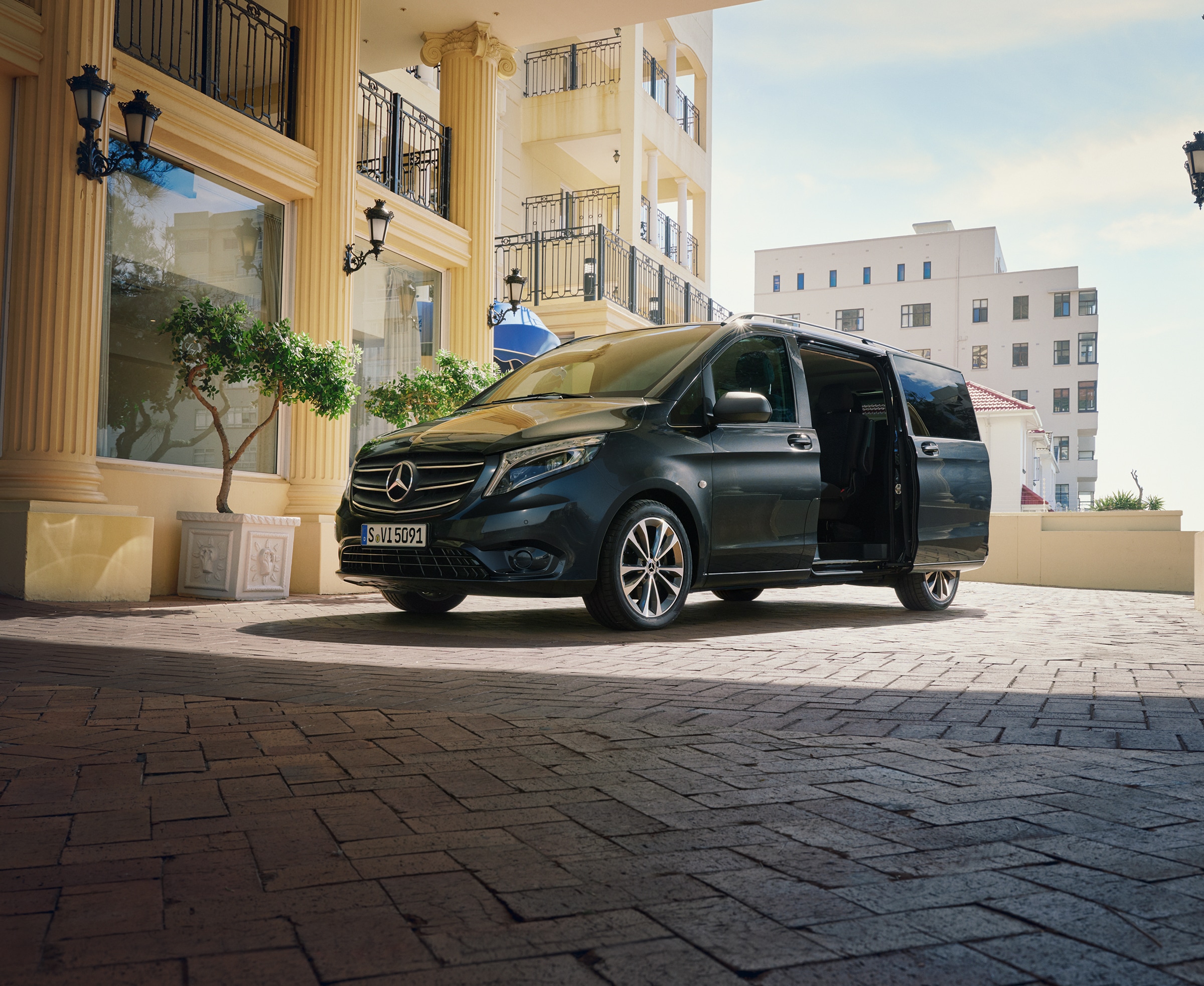 Trasportare con Vito Tourer | Tutti i modelli Vito | Veicoli commerciali Mercedes-Benz Un Mercedes‑Benz Vito Tourer parcheggiati all’ingresso di un edificio di lusso