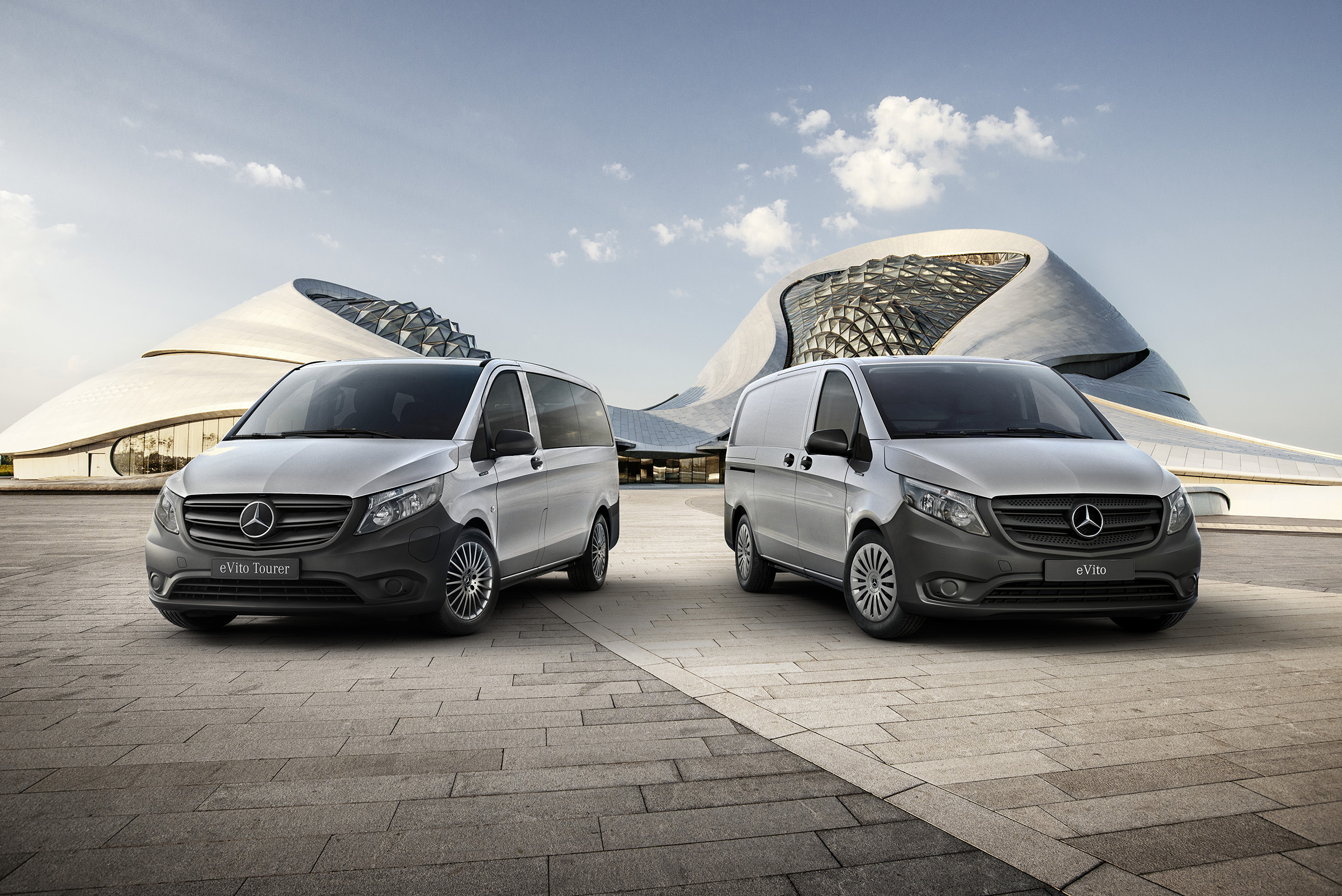 eVito Furgone e Tourer | Tutti i modelli Vito | Mercedes-Benz Un eVito furgone e un eVito Tourer davanti a un edificio futuristico