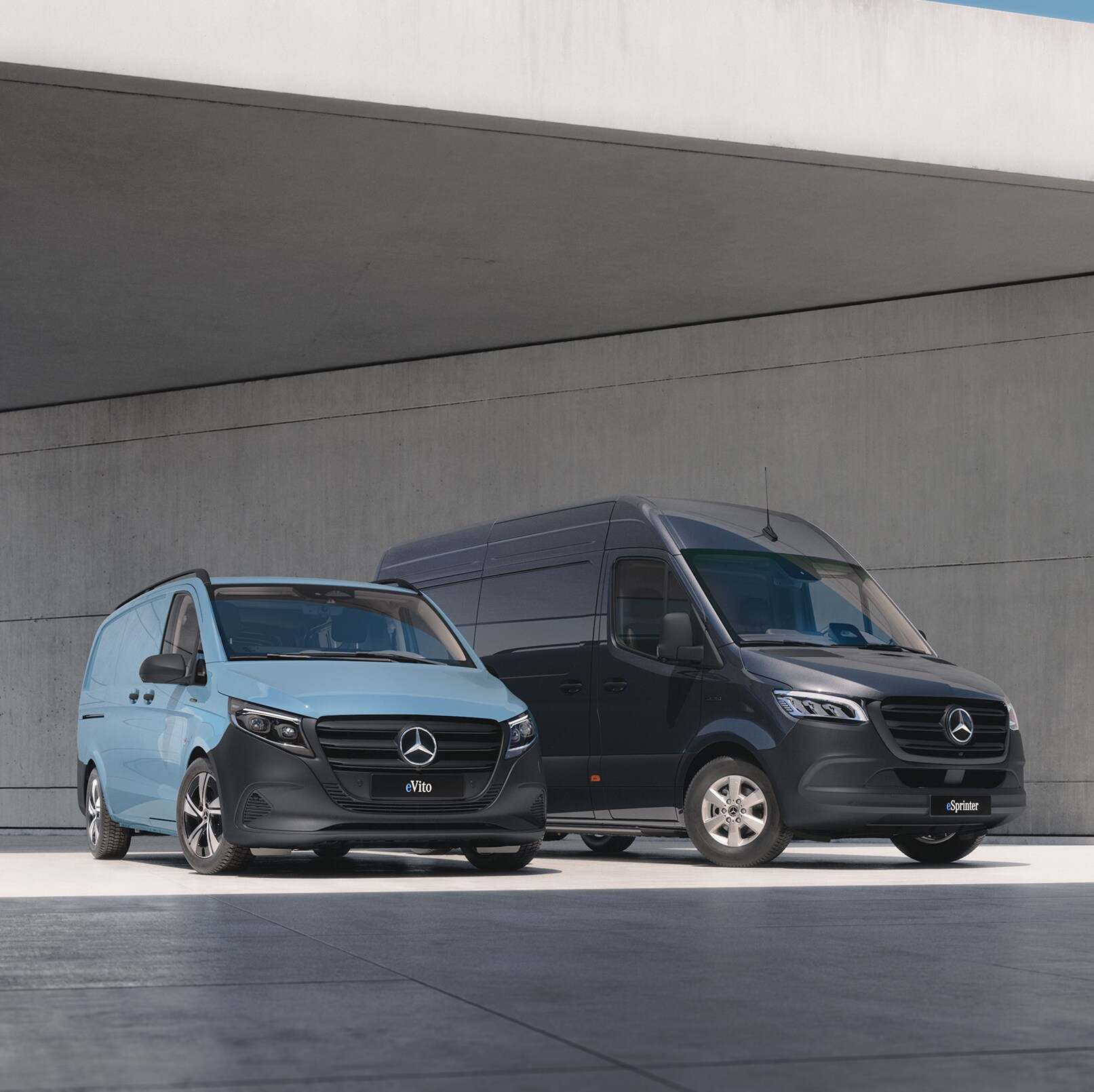 Due furgoni davanti a un edificio moderno in cemento.