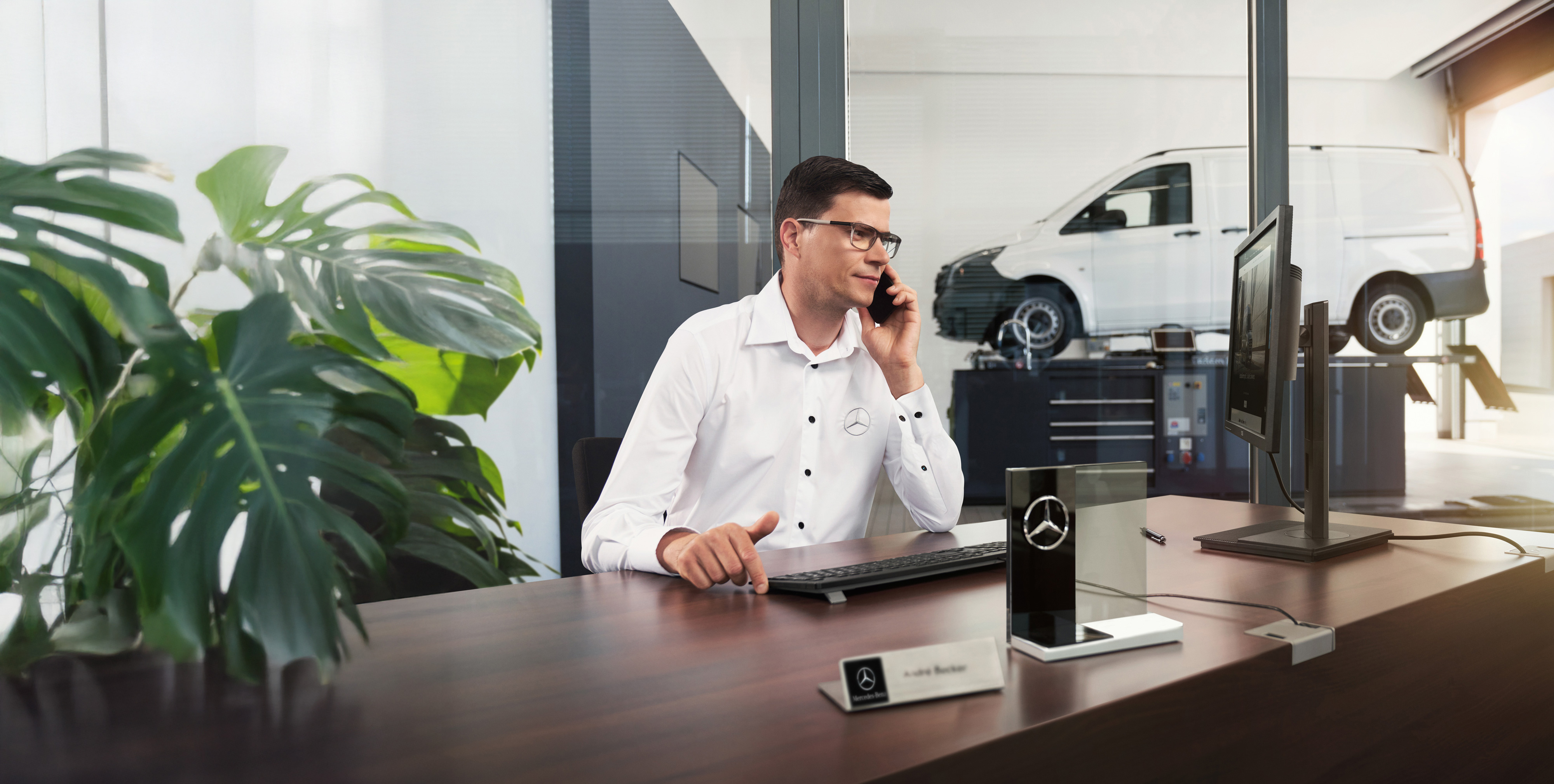 Mercedes-Benz | Transporterbetreuung Mercedes-Benz Mitarbeiter telefoniert an einem Schreibtisch.