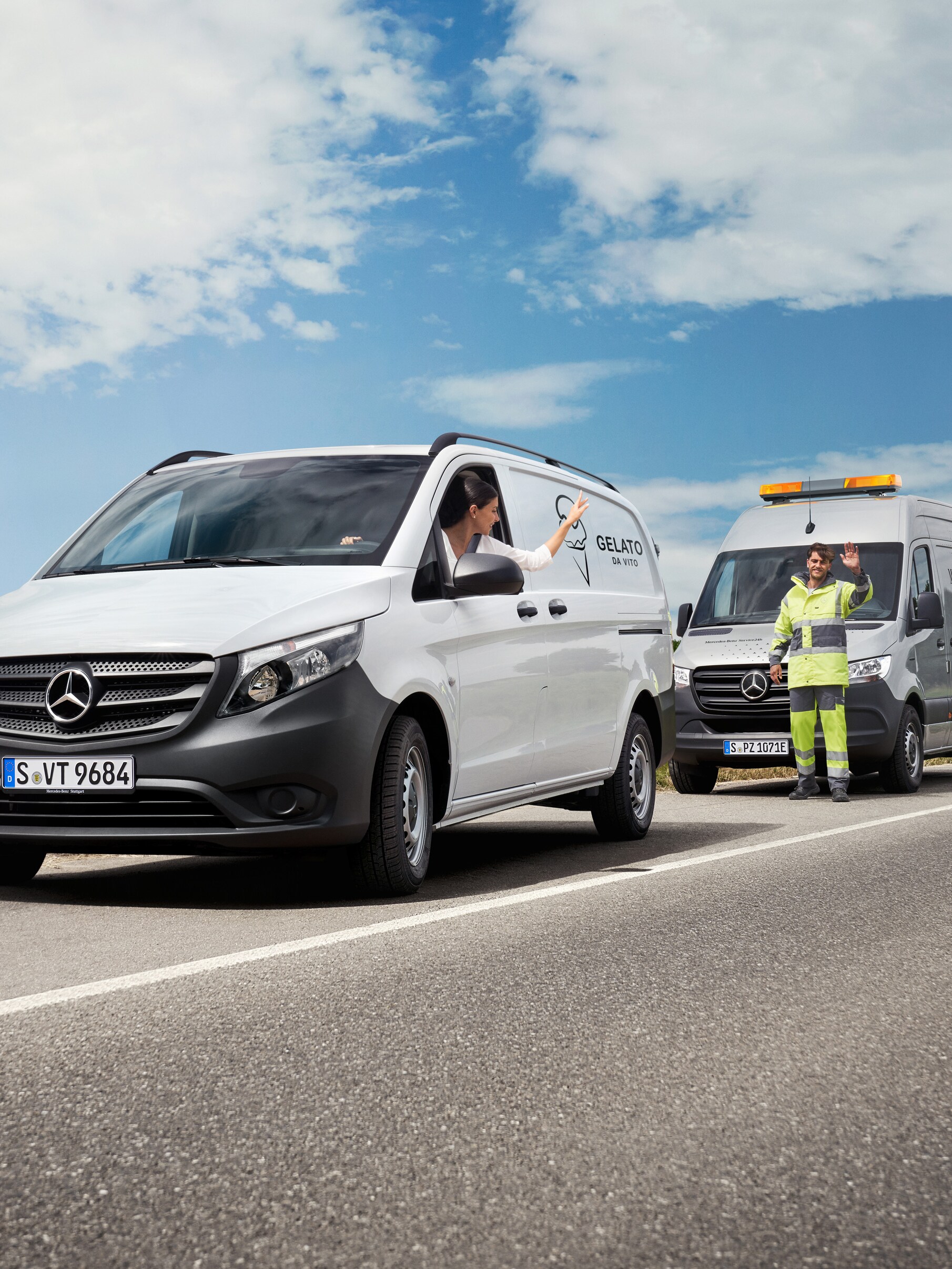 Eine Frau, die in einem weißen Mercedes-Benz Vito sitzt, winkt einem Mercedes-Benz Servicetechniker am Straßenrand zu.