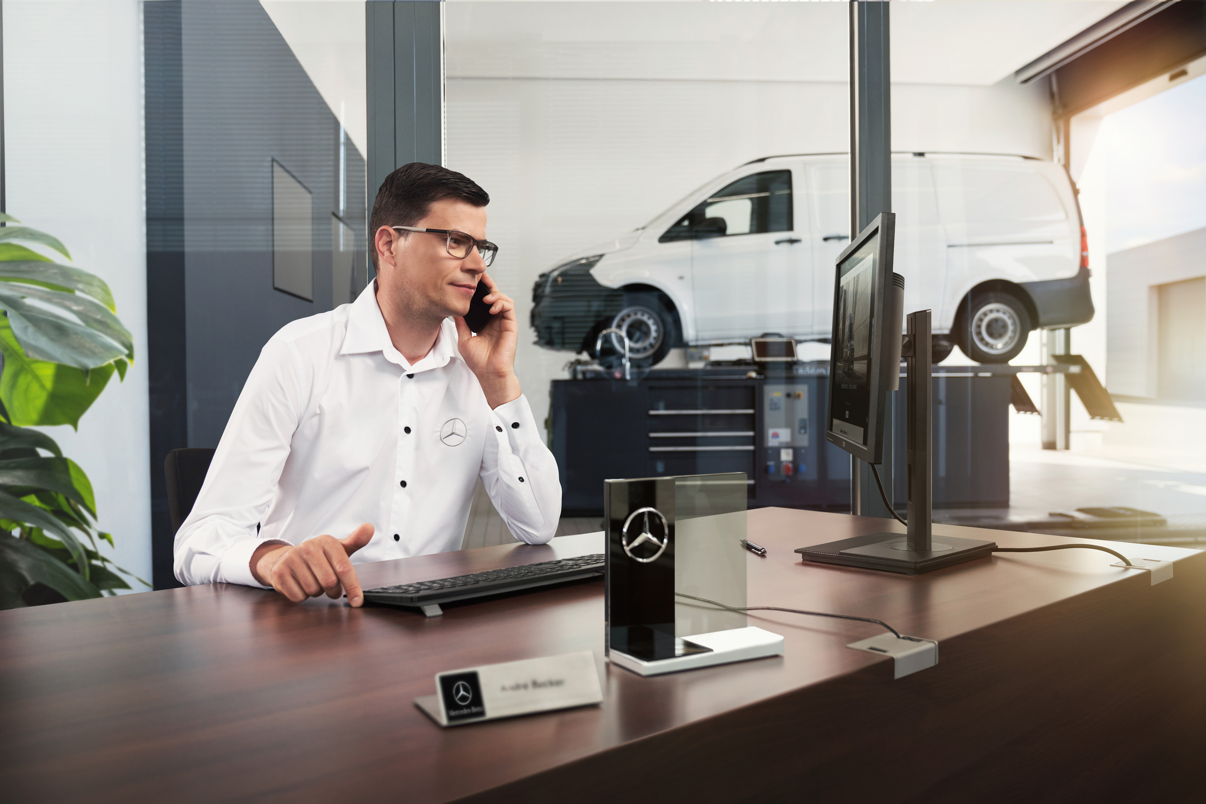 Mercedes-Benz | Komfort | Service-Partner Mercedes-Benz Serviceberater telefoniert in einer Werkstatt.
