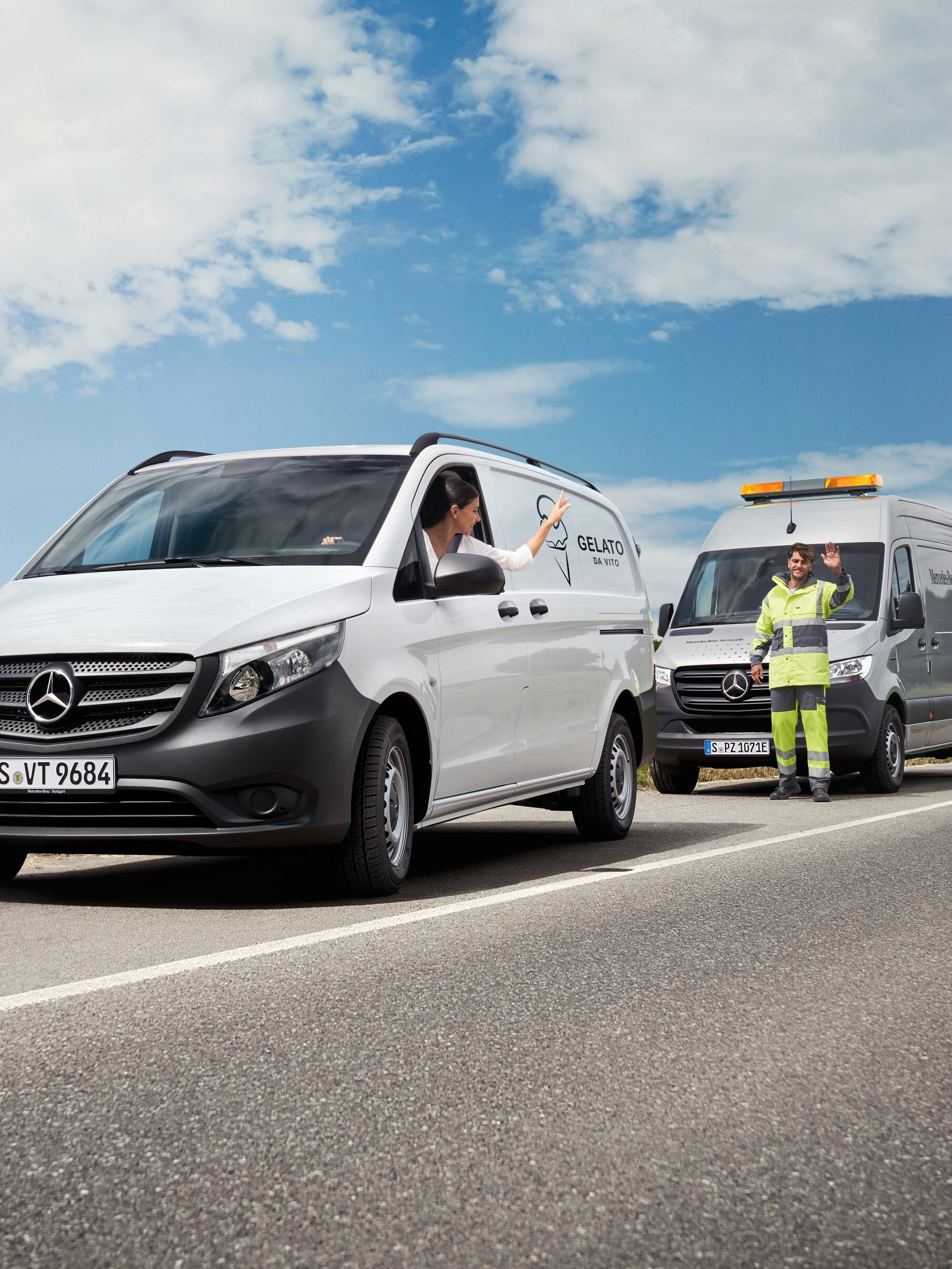Una donna seduta in un Mercedes-Benz Vito bianco saluta un tecnico dell'assistenza Mercedes-Benz sul lato della strada.
