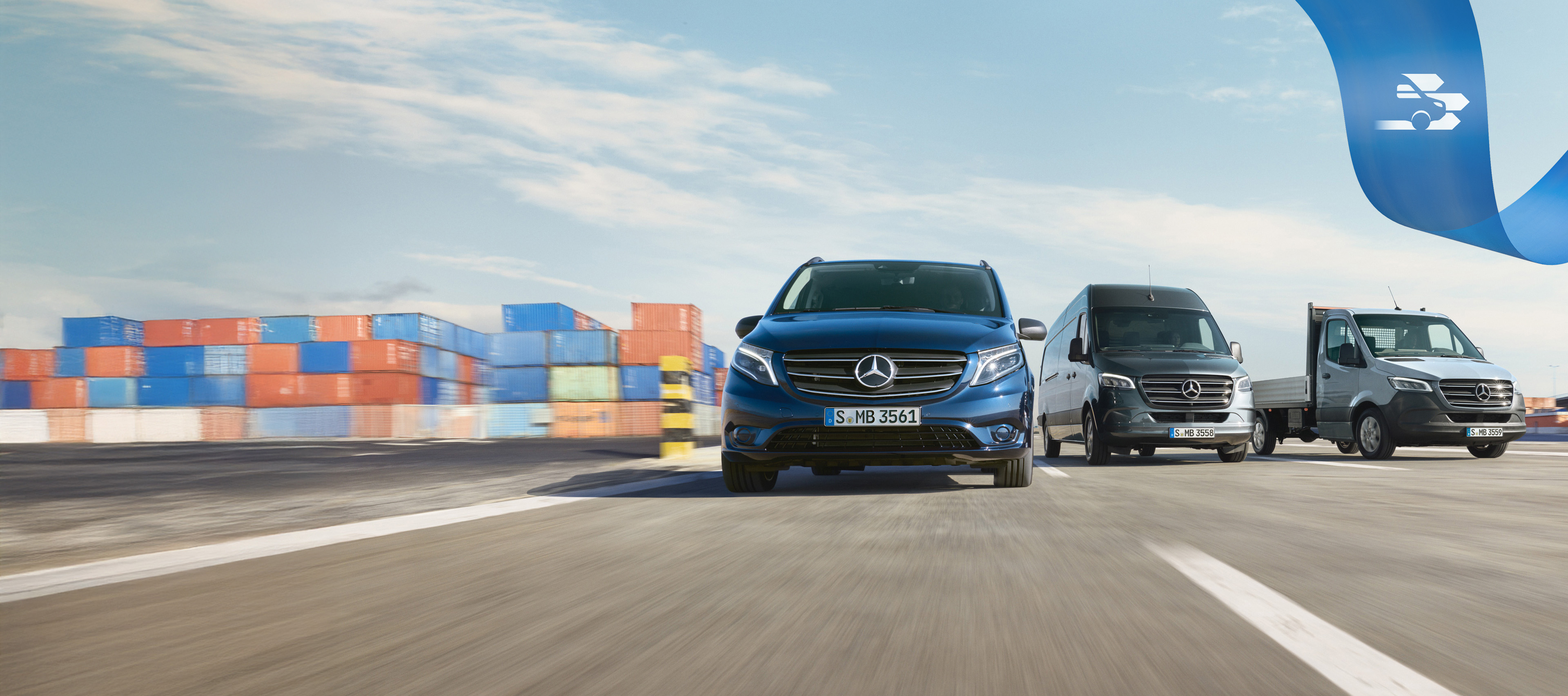 Mercedes Benz | Convenience Mobilovan Una serie di veicoli commerciali Mercedes-Benz su una strada, sullo sfondo alcuni container.