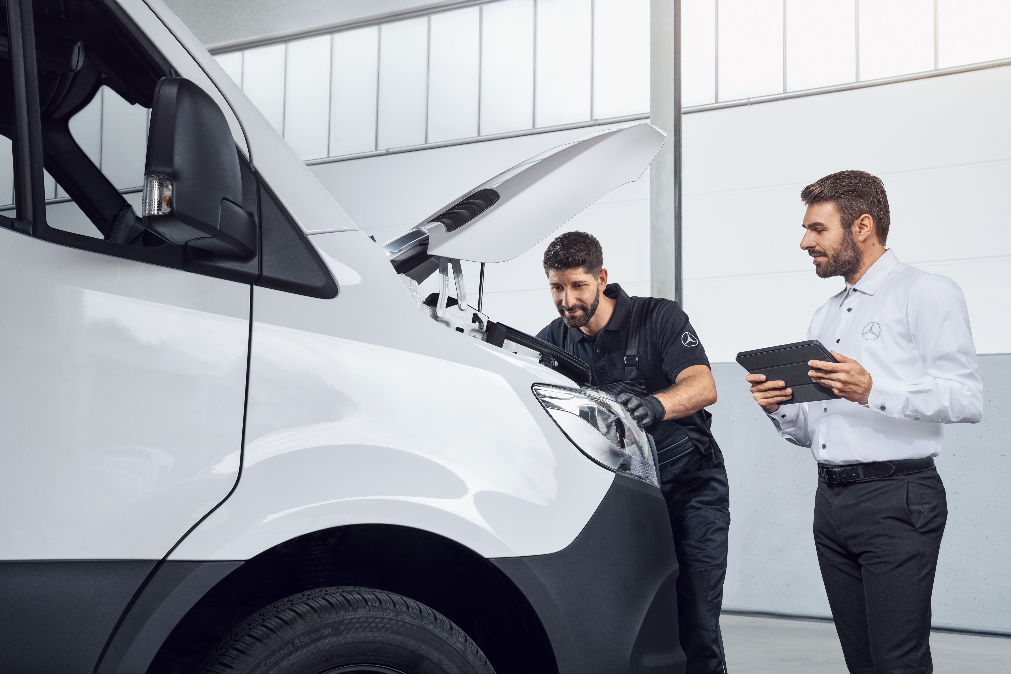 Mercedes-Benz | Ricambi originali di qualità per i veicoli commerciali Due uomini mentre testano un Mercedes Sprinter con tablet e cofano aperto, argomento: ricambi per il Mercedes-Benz Sprinter.