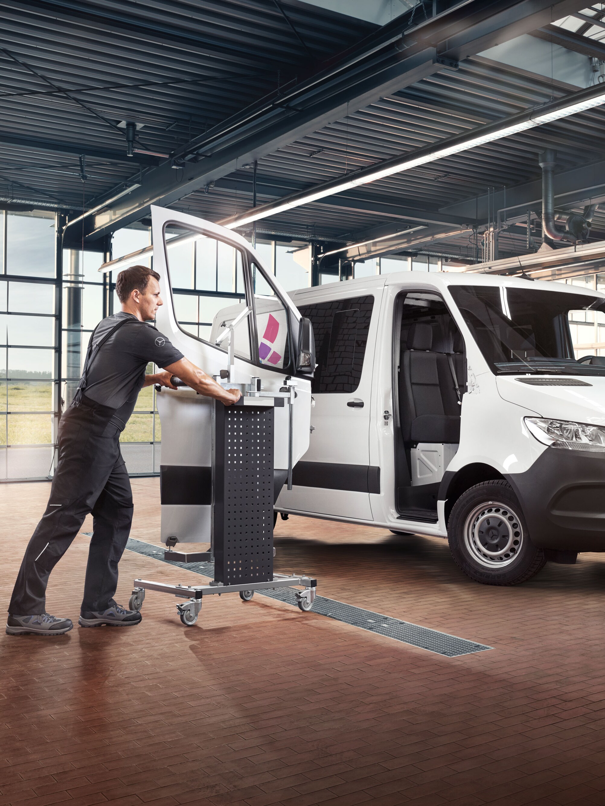 Spécialiste Mercedes utilisant Mercedes-Benz Xentry et des outils spéciaux sur un utilitaire léger dans un atelier moderne.